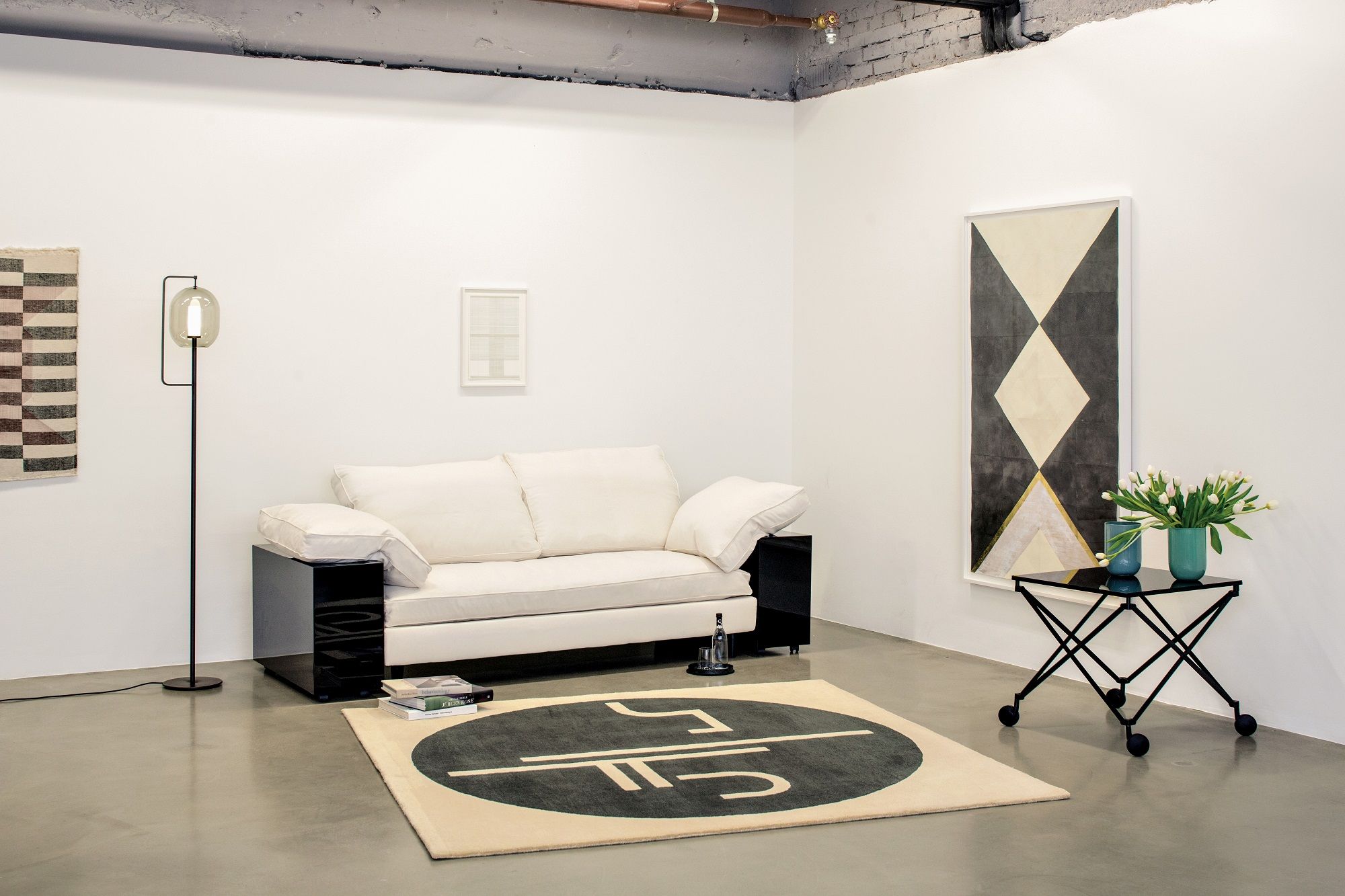 Helles Lota Sofa von Classicon in modernem Wohnzimmer mit Teppich, Tisch und Kunst.