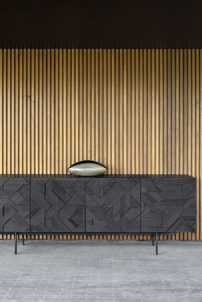 Schwarze Graphic Teak Anrichte von Ethnicraft mit geometrischen Mustern und einer dekorativen Schale darauf.