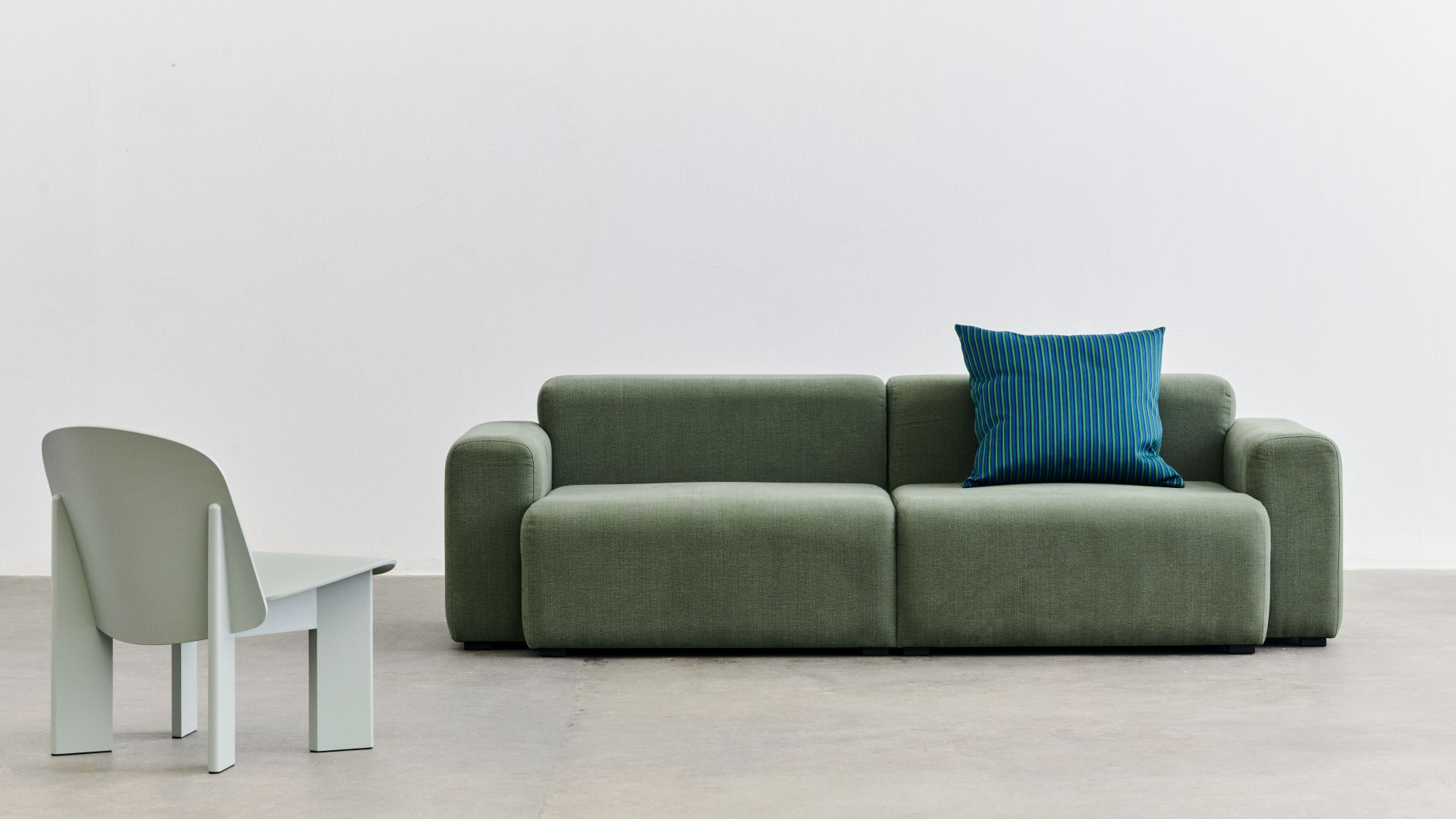Mags Sofa in Grün mit Kissen und Stuhl, modernes Wohnzimmer Design.