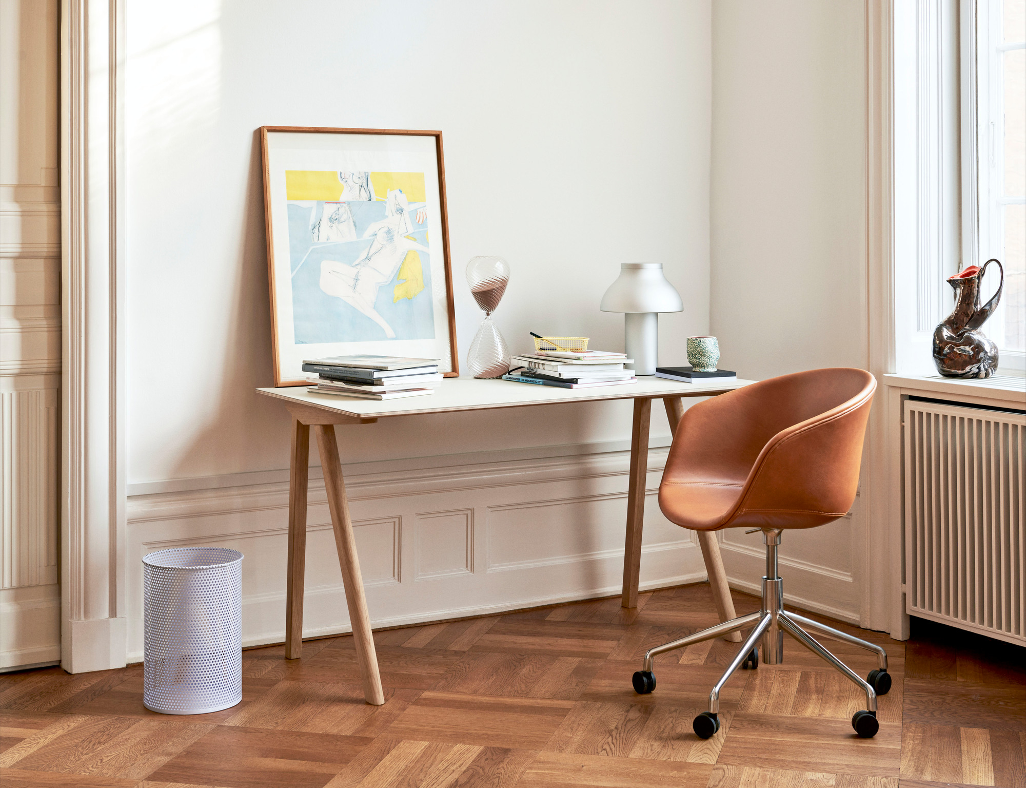 Heller Raum mit Copenhague Table CPH 90 Schreibtisch von Hay, Bürostuhl, Lampe und Dekoration auf Parkettboden.