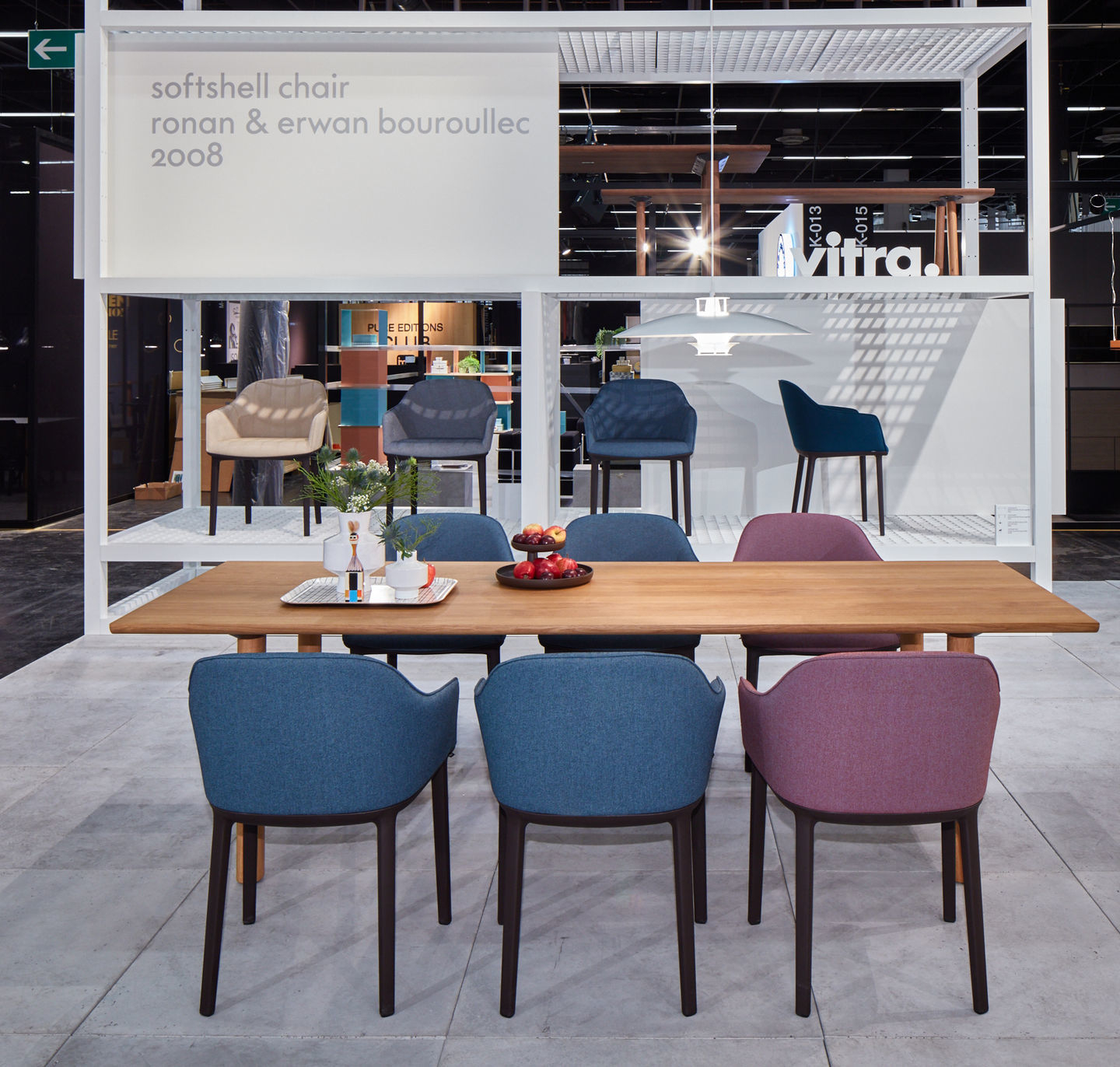 Vitra Softshell Chair mit Vierfußgestell in verschiedenen Farben an einem Esstisch.