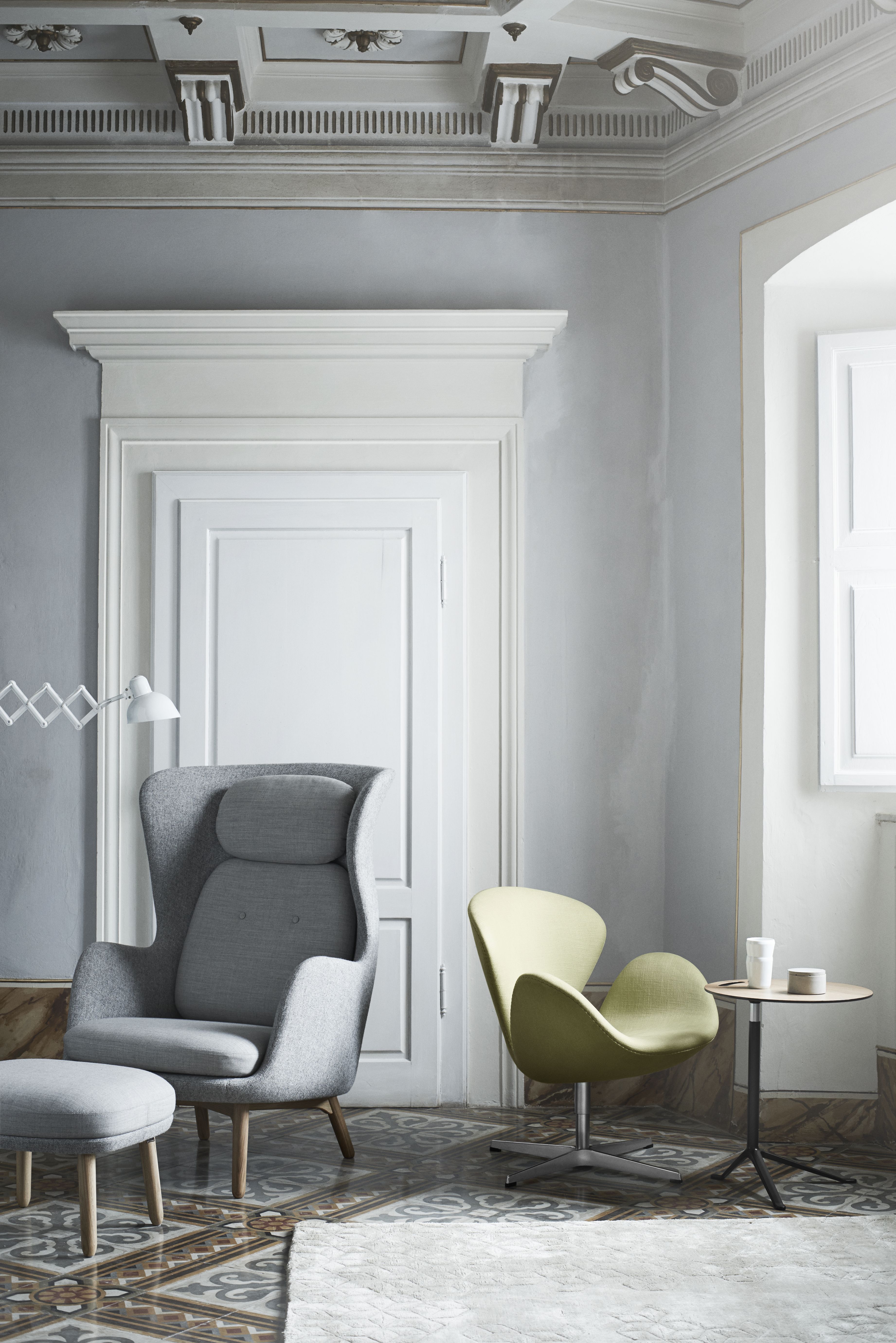 Grauer Ro Sessel von Fritz Hansen mit Hocker und hellgrüner Sessel in stilvollem Interieur.
