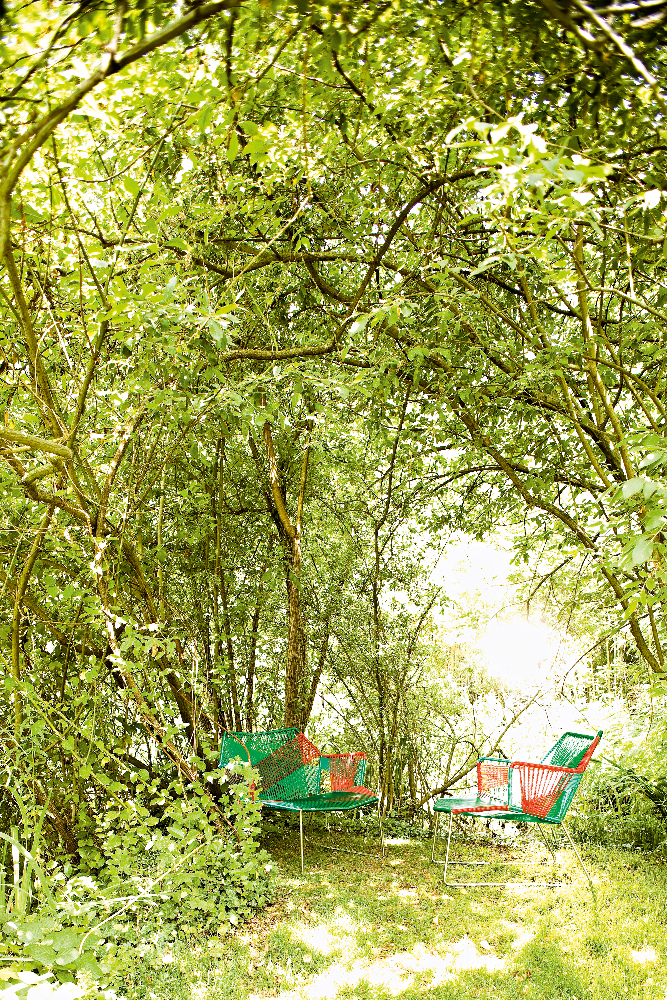 Zwei Tropicalia Outdoor Sessel von Moroso im Garten unter Bäumen, grüne und rote Farbkombination.