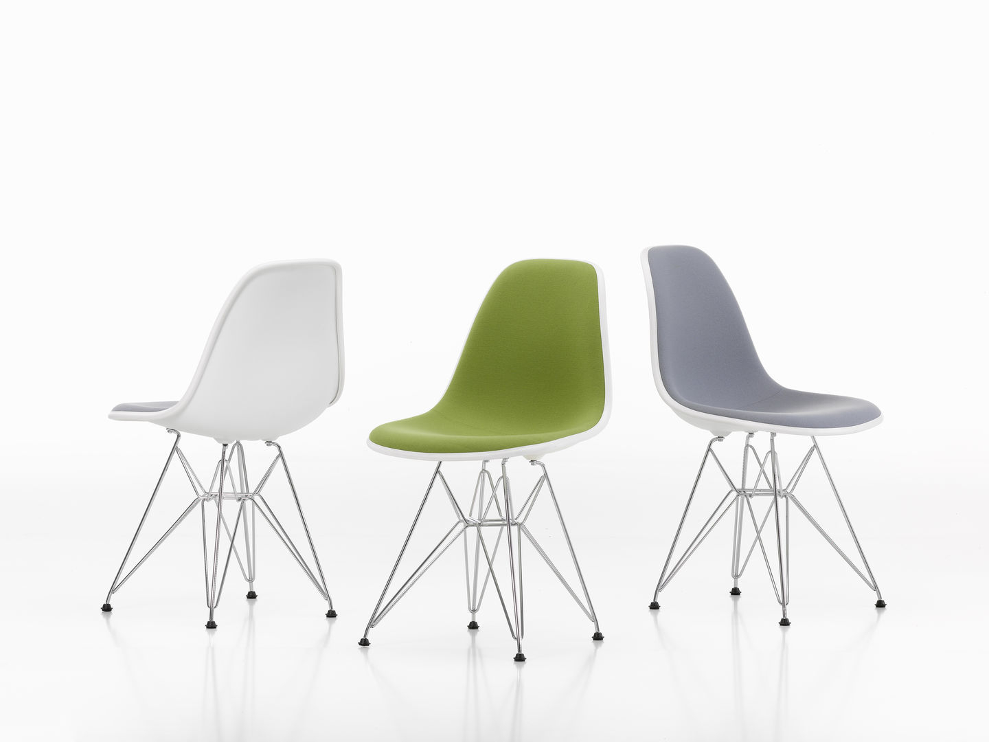Drei Eames Plastic Side Chairs DSR von Vitra in Weiß, Grün und Grau mit Chromgestell.