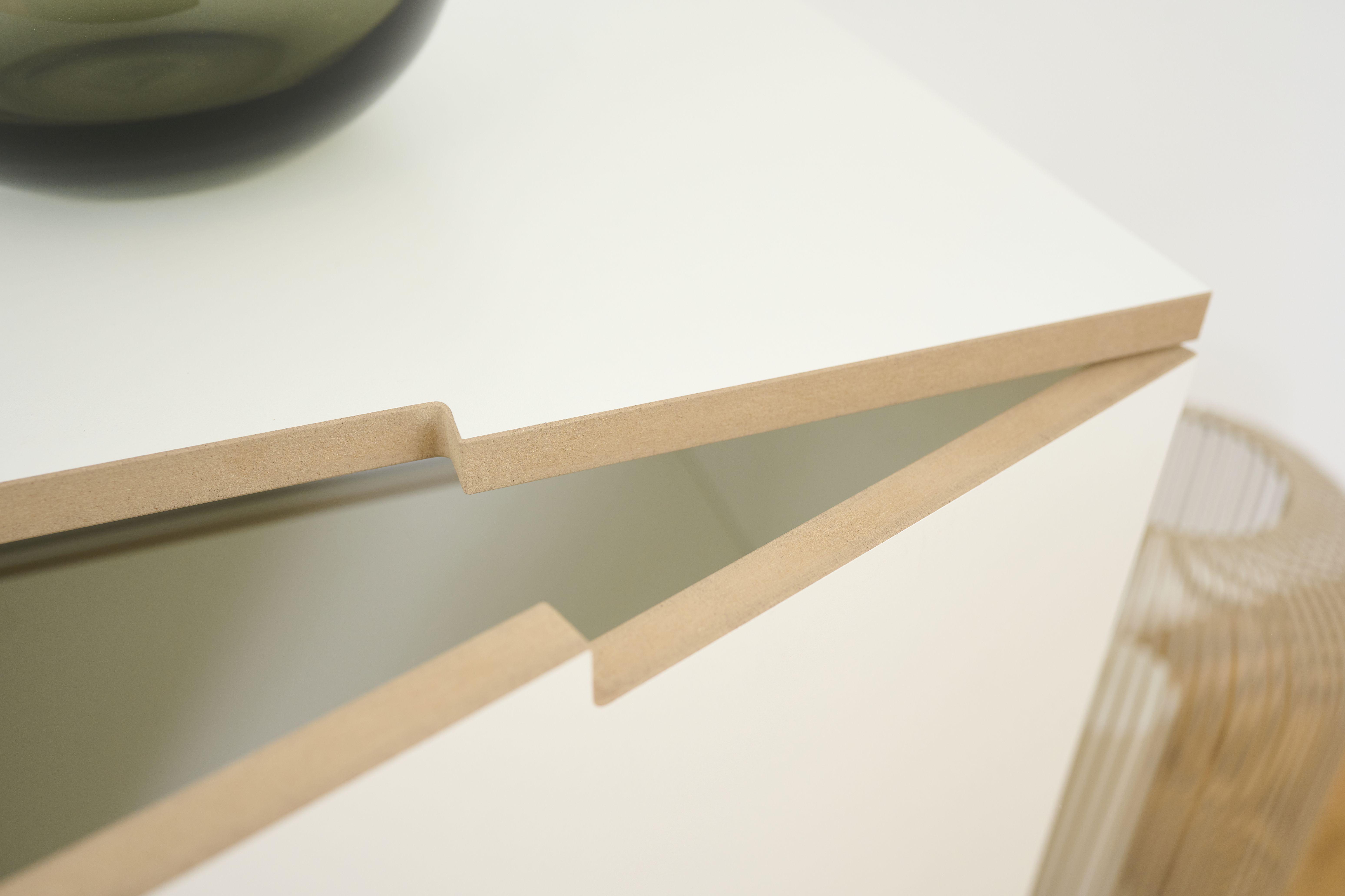 Detailaufnahme des Tojo Sideboards in Weiß mit offenem Schubfach und Holzdetails.