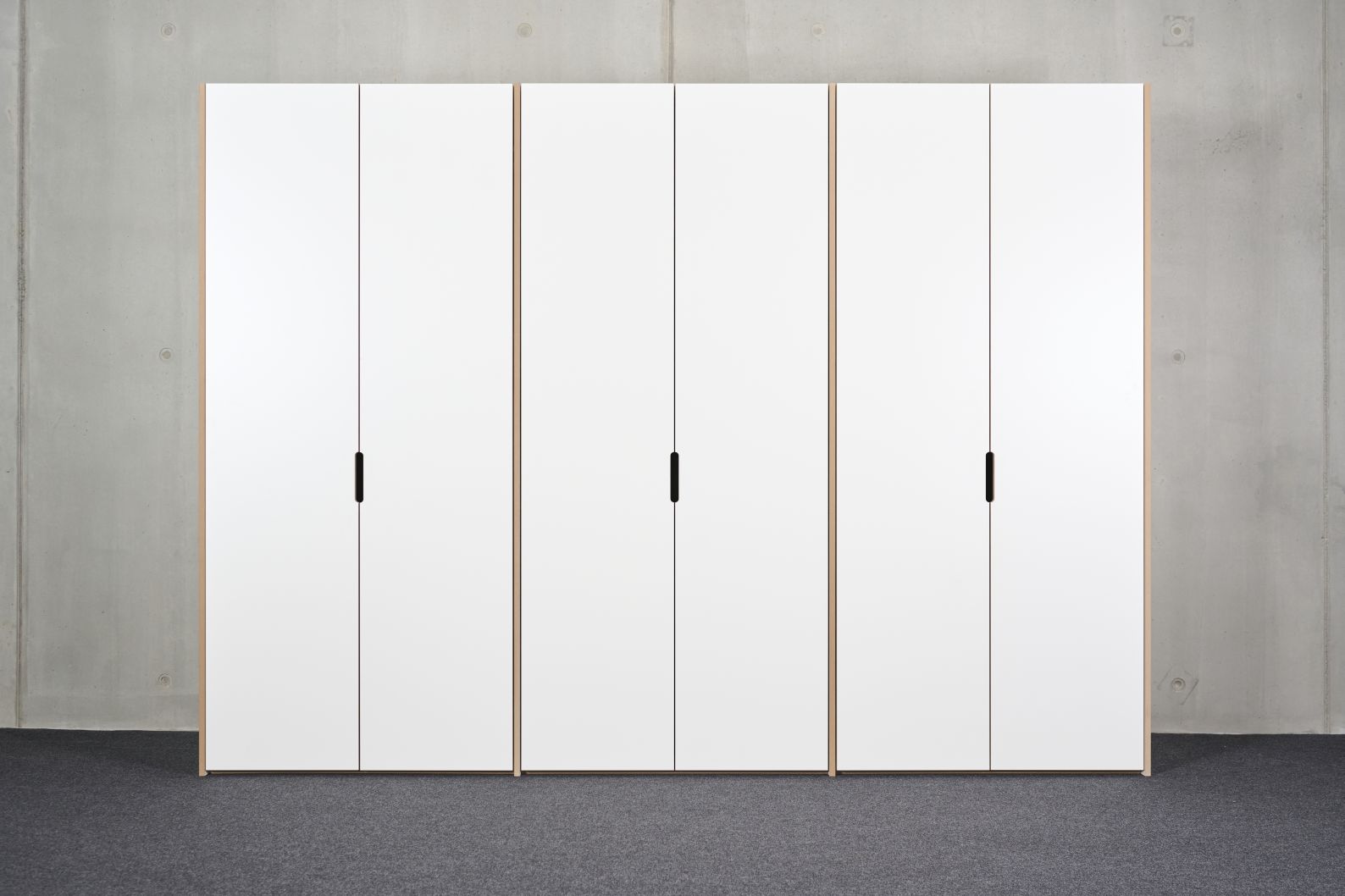 Tojo Schrank Grundmodul, weißes Schranksystem mit drei Modulen und minimalistischen schwarzen Griffen.