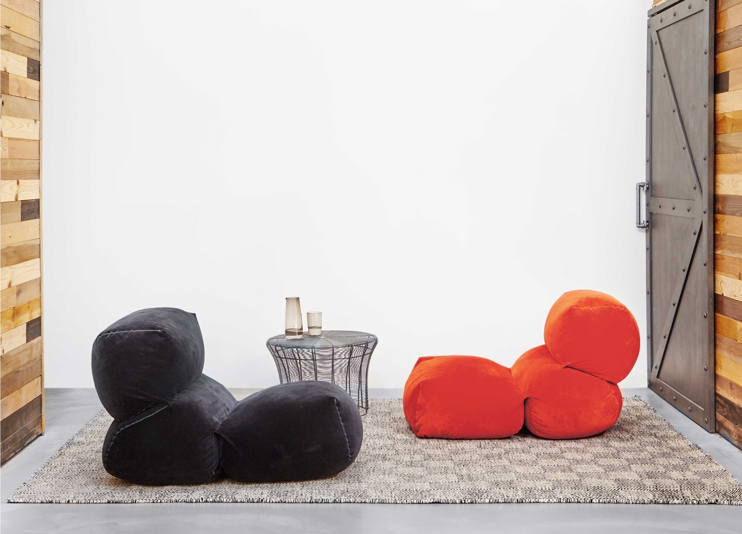 GAN Grapy Sitzkissen in Schwarz und Orange auf einem Teppich, modernes Wohnzimmer-Interieur.