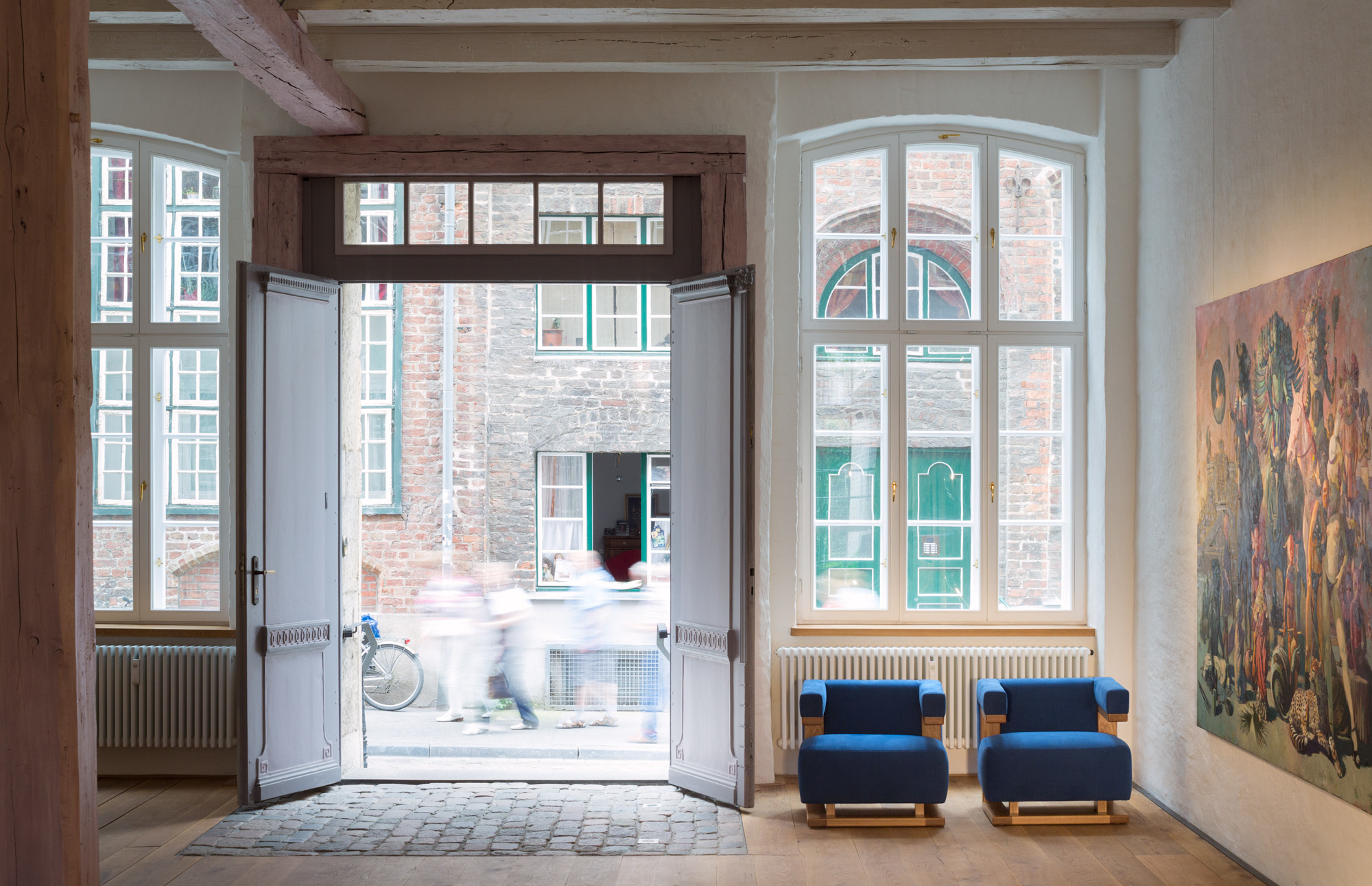 Zwei blaue Gropius F51 Sessel Bauhaus Reedition Tecta vor geöffneter Tür in historischem Gebäude.