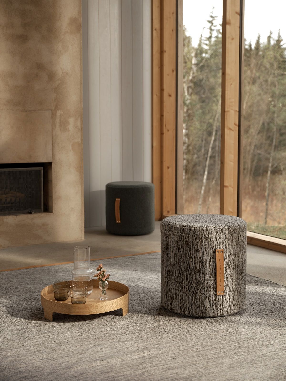 Dunkelgrauer Björk Hocker von Design House Stockholm im modernen Wohnzimmer mit Teppich und Kamin.