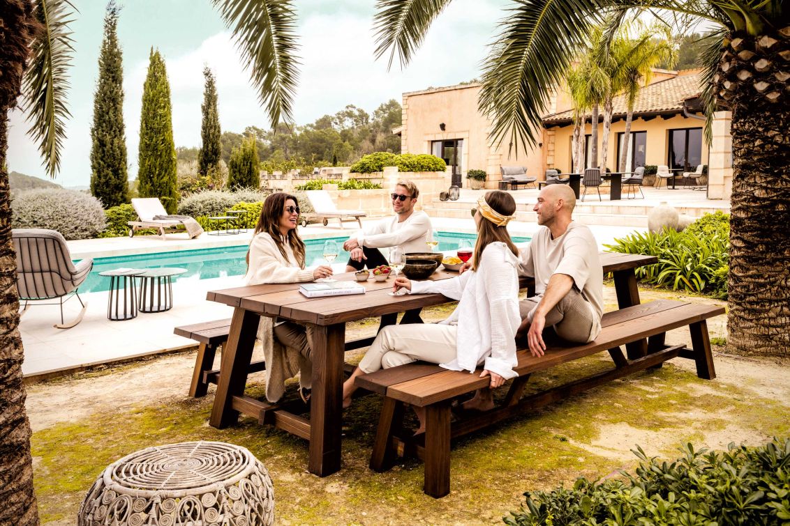BC 08 Cantina Outdoor Sitzbank von Janua: Holzbank für Garten oder Terrasse mit Personen.