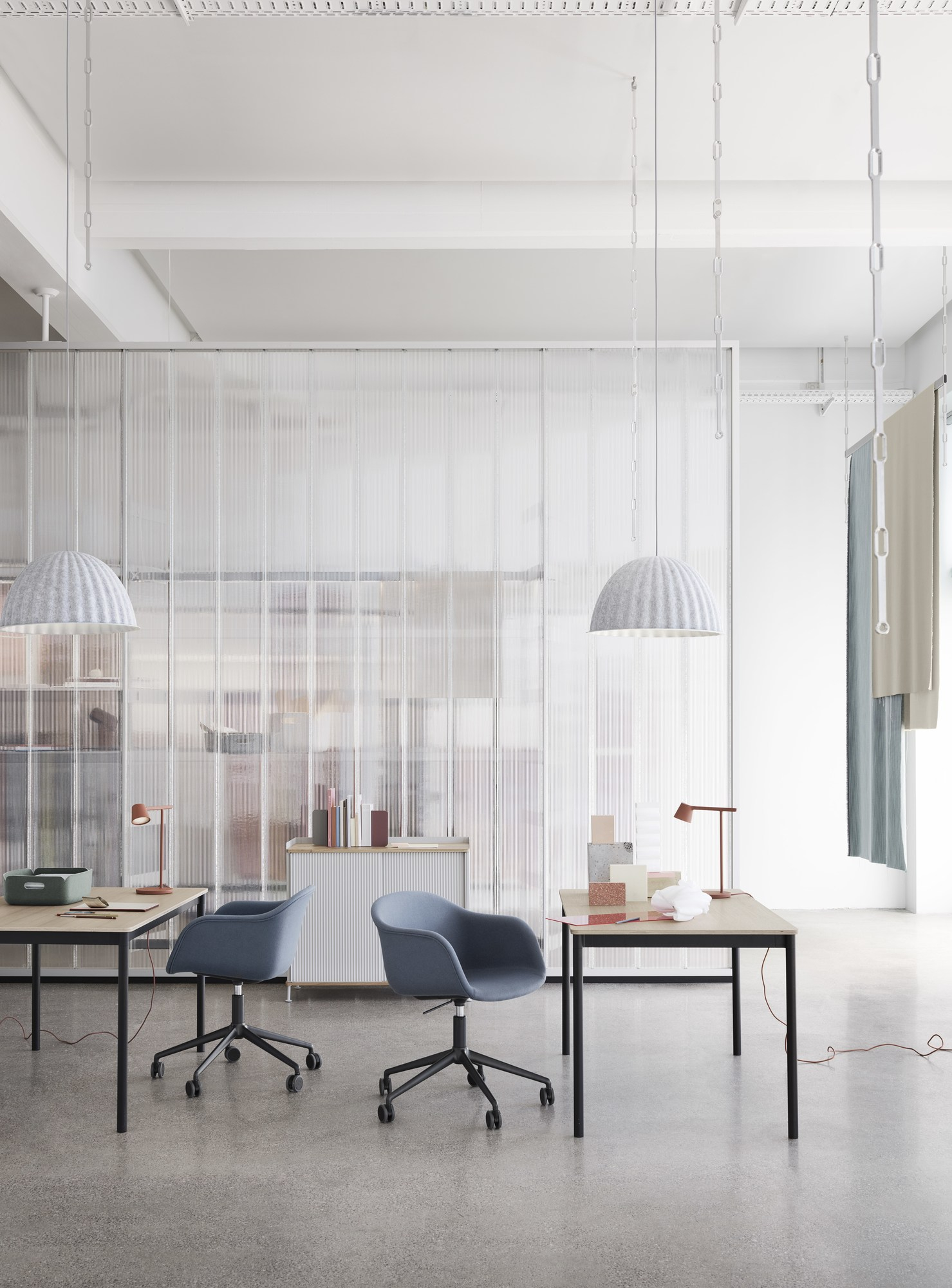 Helle Büroeinrichtung mit zwei Under The Bell Pendelleuchten von Muuto und modernen Büromöbeln.