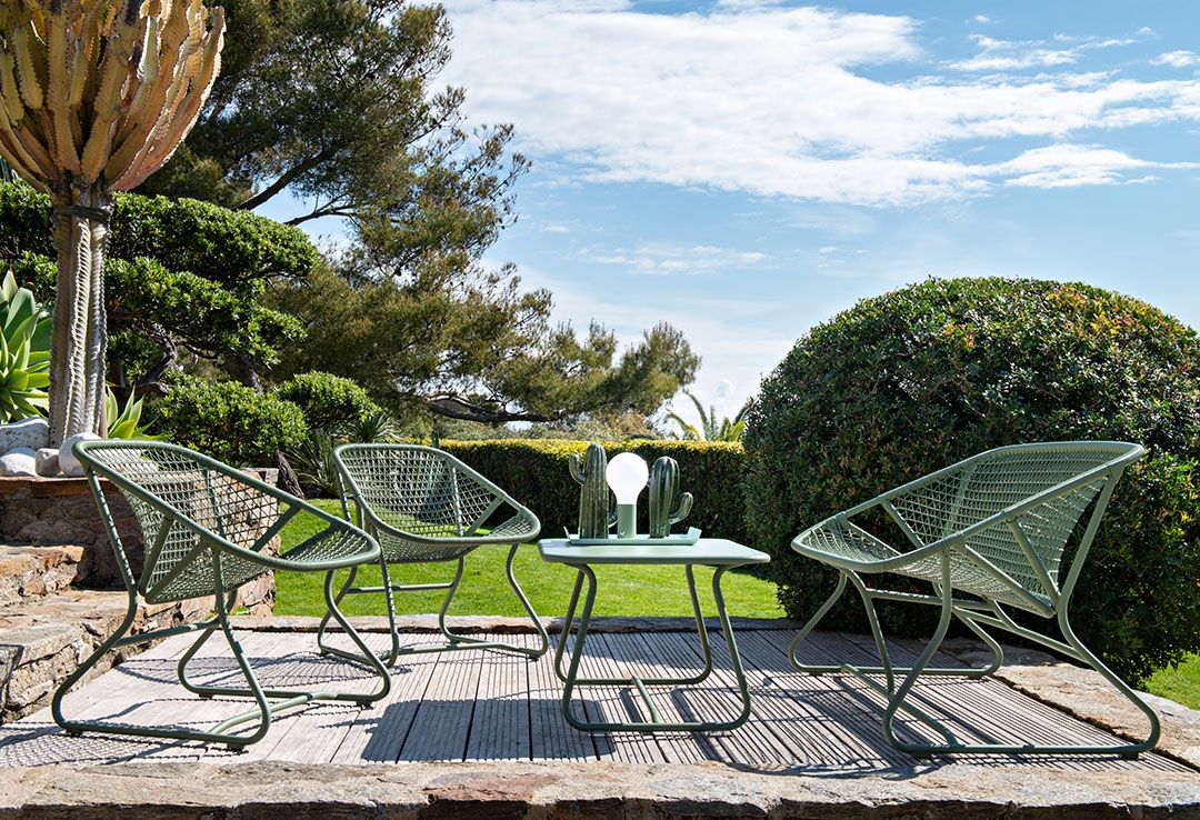Grüne Sixties Outdoor Möbel: Niedriger Tisch und Sessel von Fermob im Garten.
