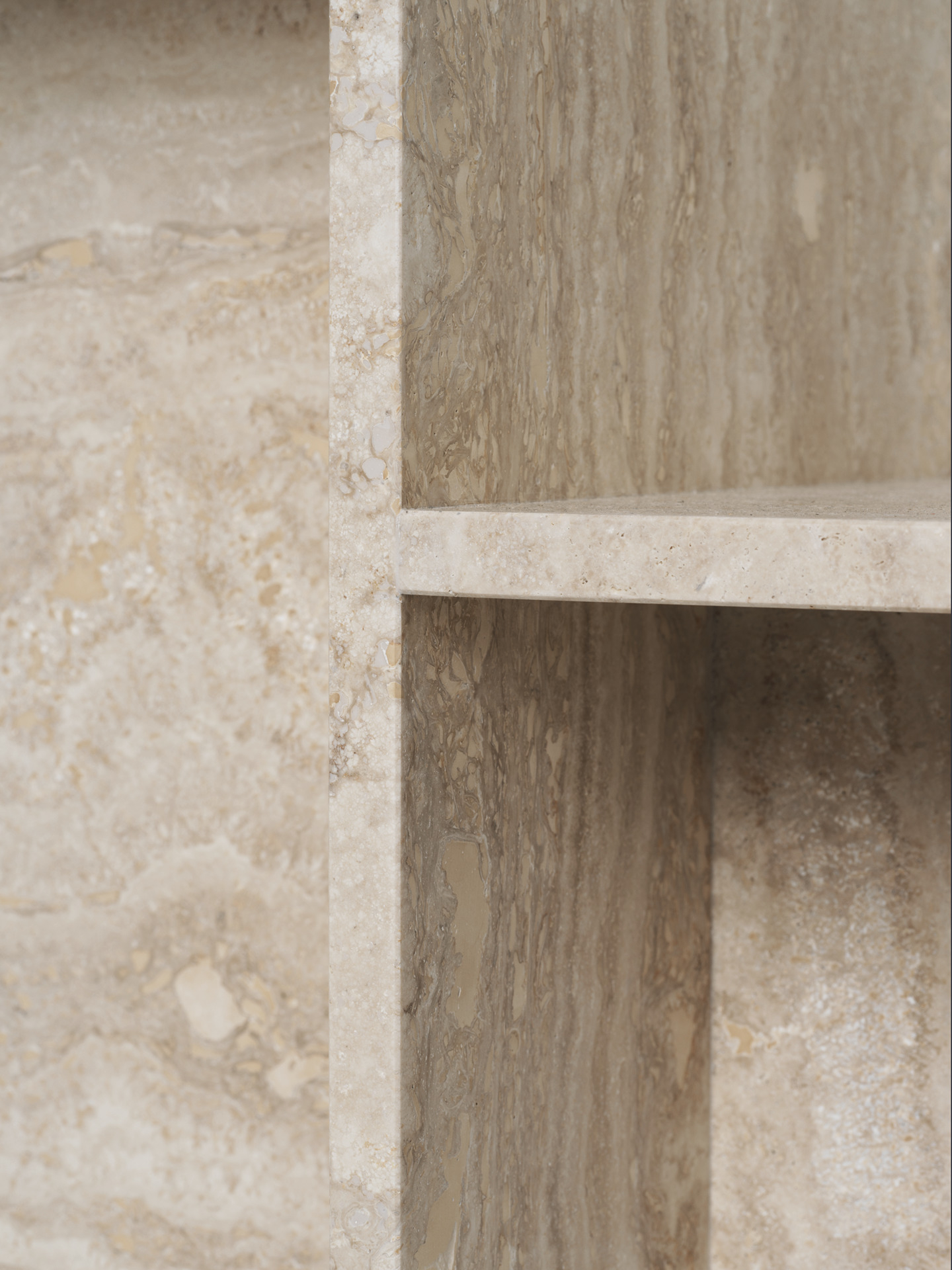 Detailaufnahme des Ferm Living Distinct Beistelltisches aus Travertin mit Ablagefläche.