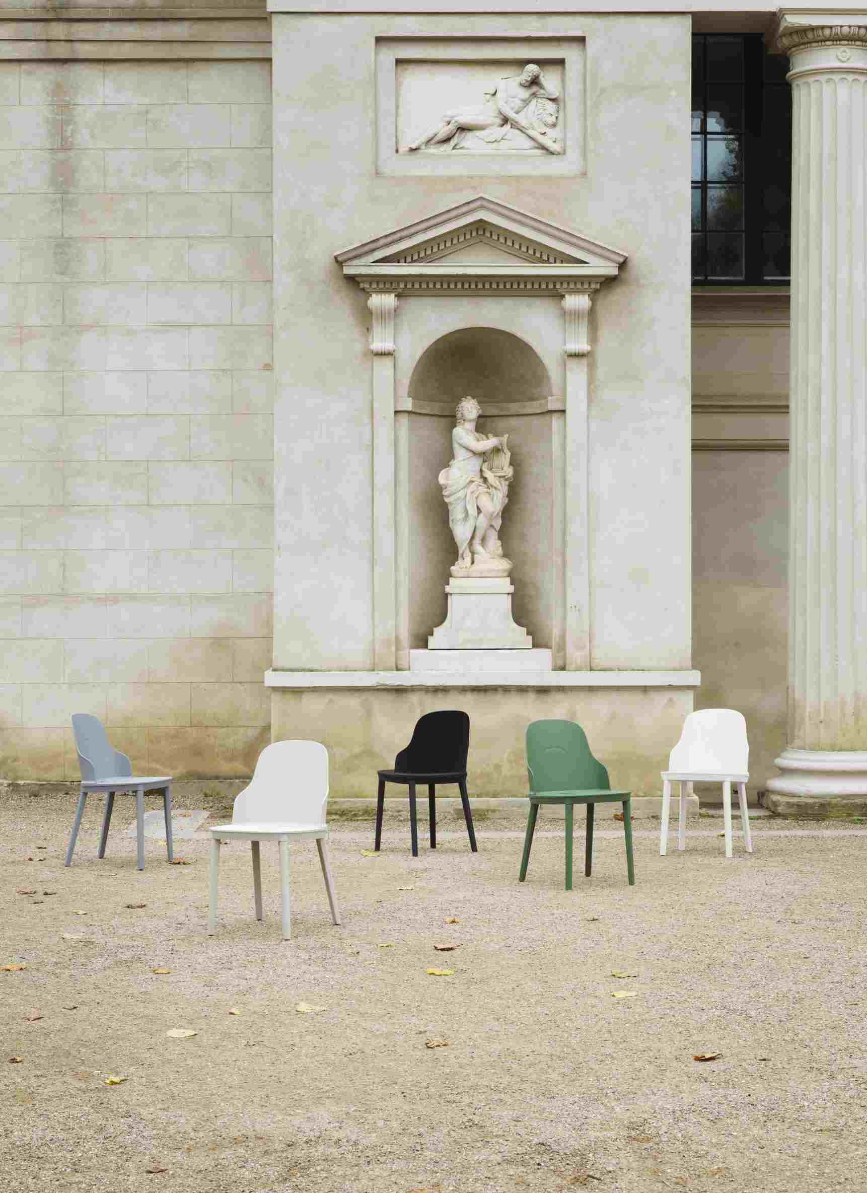 Fünf Allez Stühle von Normann Copenhagen in verschiedenen Farben vor einem Gebäude mit Statue.