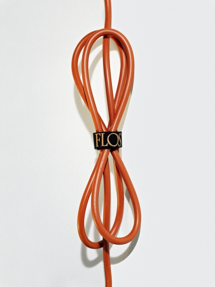 Detailaufnahme des orangefarbenen Kabels der Bilboquet Tischleuchte von Flos mit schwarzem Kabelbinder.