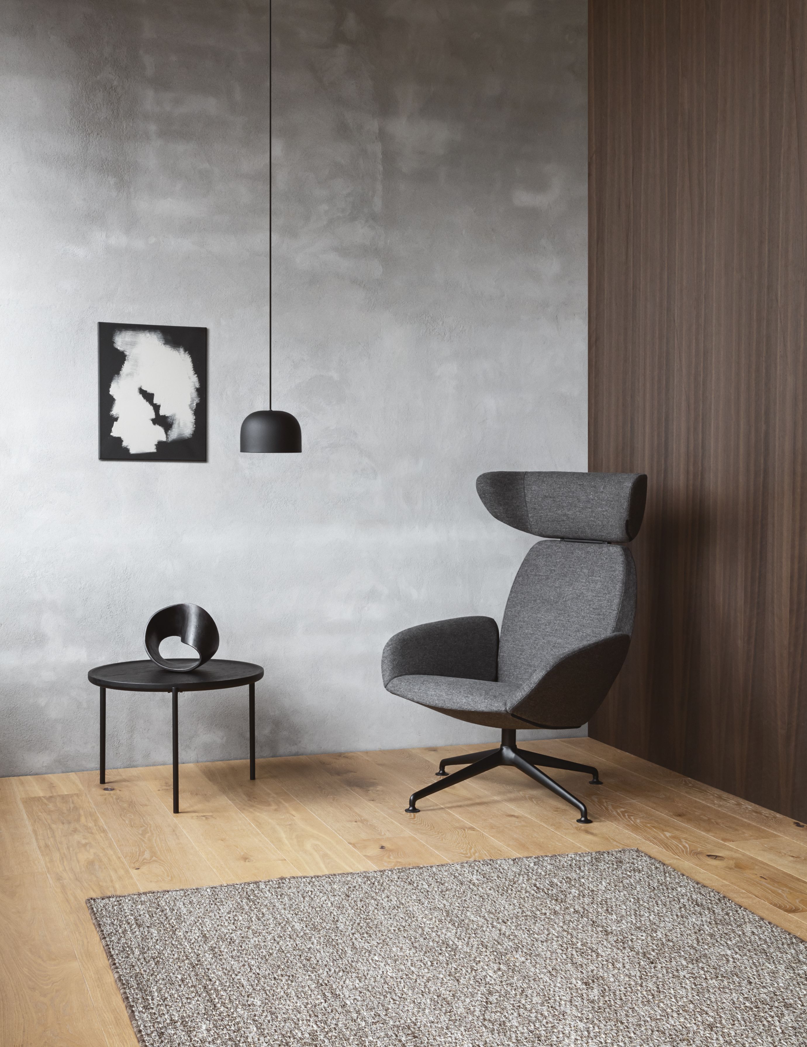 Grauer Laze Sessel von Eva Solo mit hoher Rückenlehne, schwarzem Fußkreuz und modernem Design.