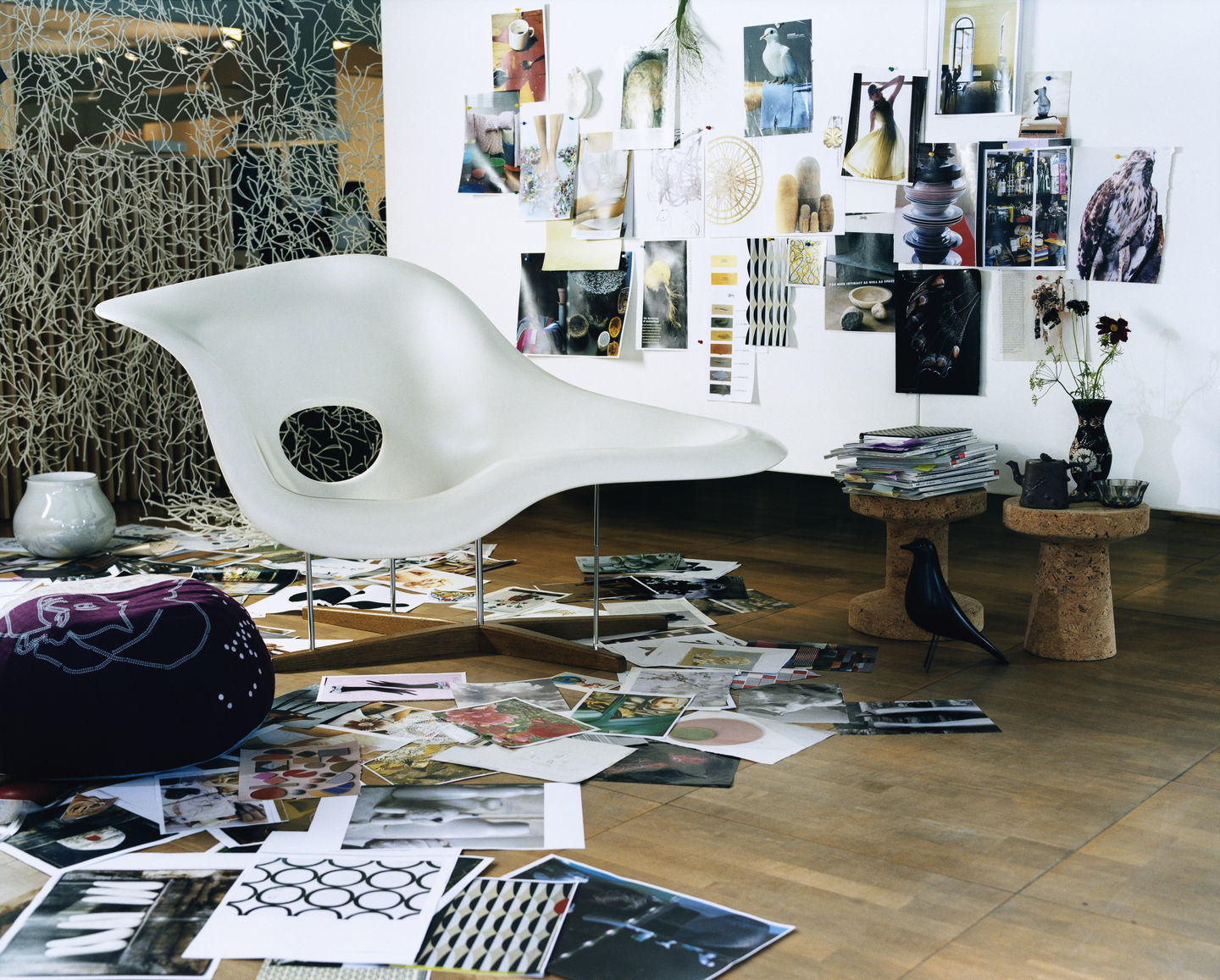 Weiße La Chaise Liege von Vitra, moderner Sessel mit Stahlgestell und Holzfuß in einem kreativen Umfeld.