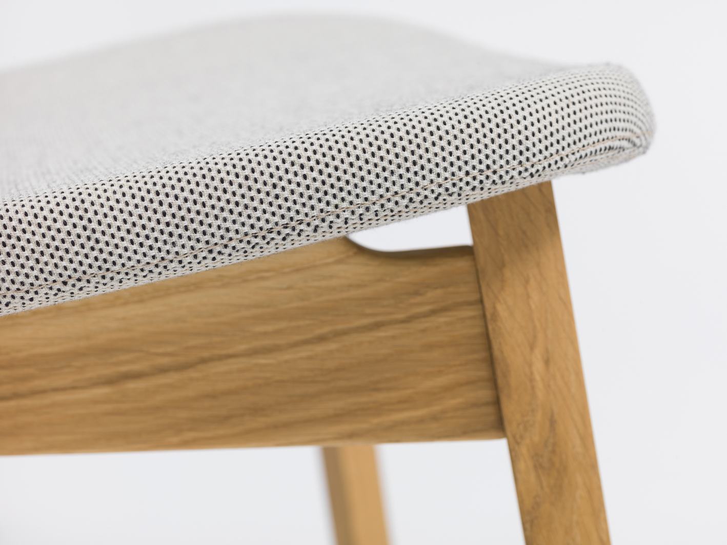 Detailaufnahme: Nonoto Lounge Chair Cocktailsessel, Sitzpolster mit Muster und Holzgestell.