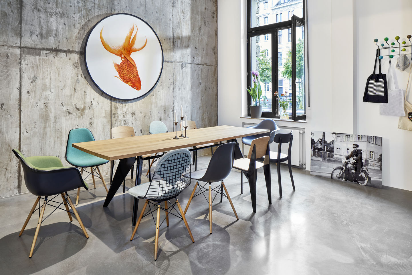 Esszimmer mit Holztisch und verschiedenen Eames Plastic Arm Chairs DAW Stühlen von Vitra.