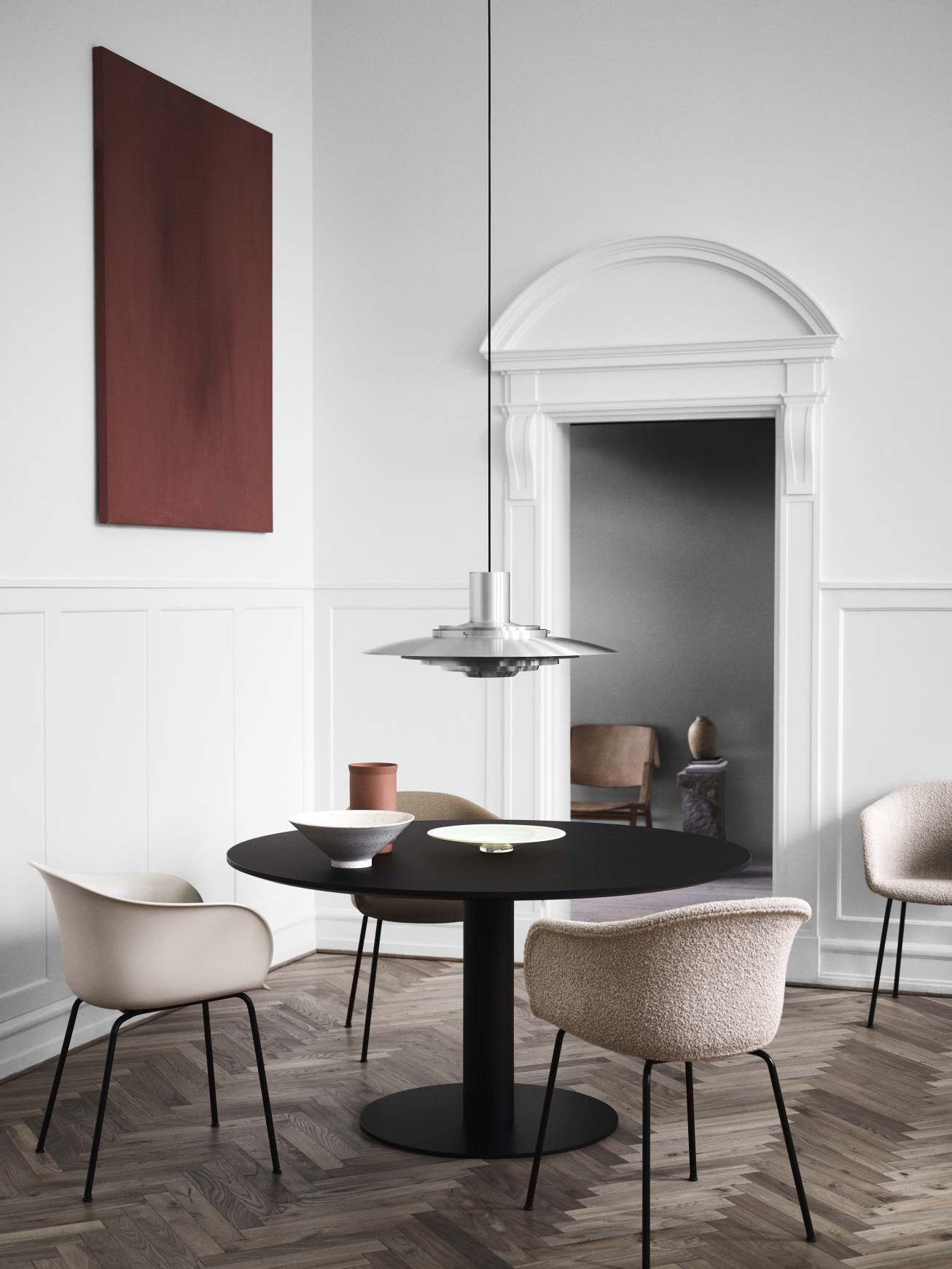 AndTradition Elefy Stuhl: Gepolsterter Sessel mit Stahlrohrgestell in beigem Stoff am Esstisch.