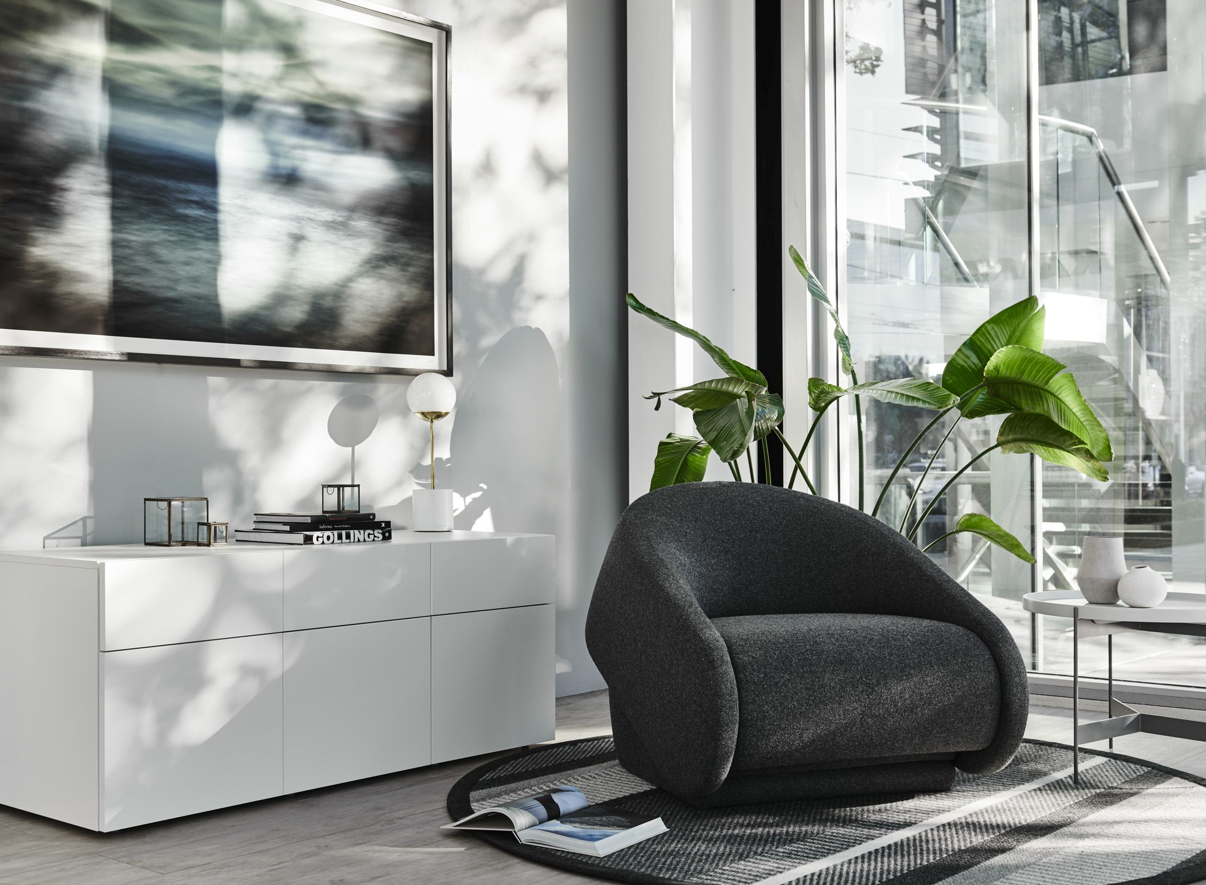 Grauer Up-lift Sessel von Prostoria im modernen Wohnzimmer mit Teppich und weißen Möbeln.