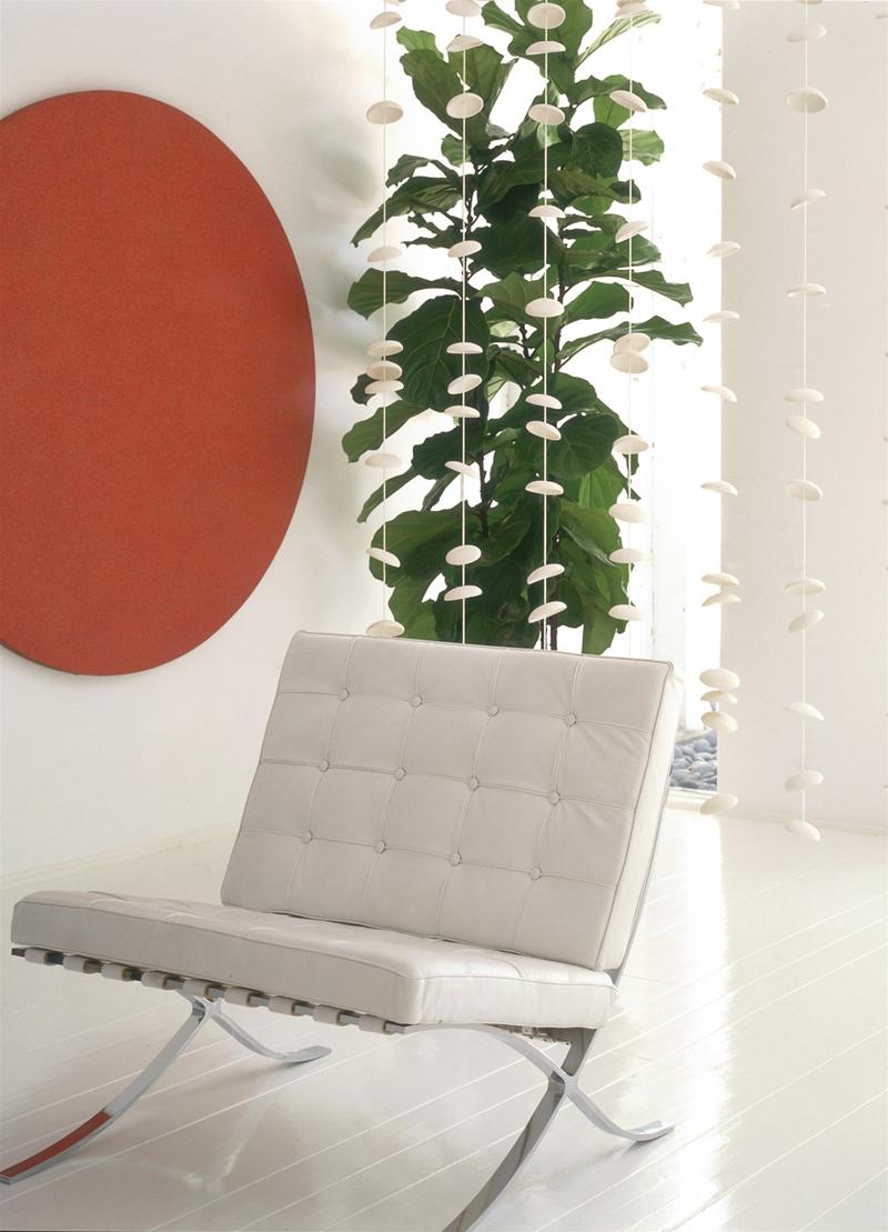 Barcelona Sessel von Knoll International in Weiß, Leder, mit Chromgestell vor Zimmerpflanze und Dekoration.