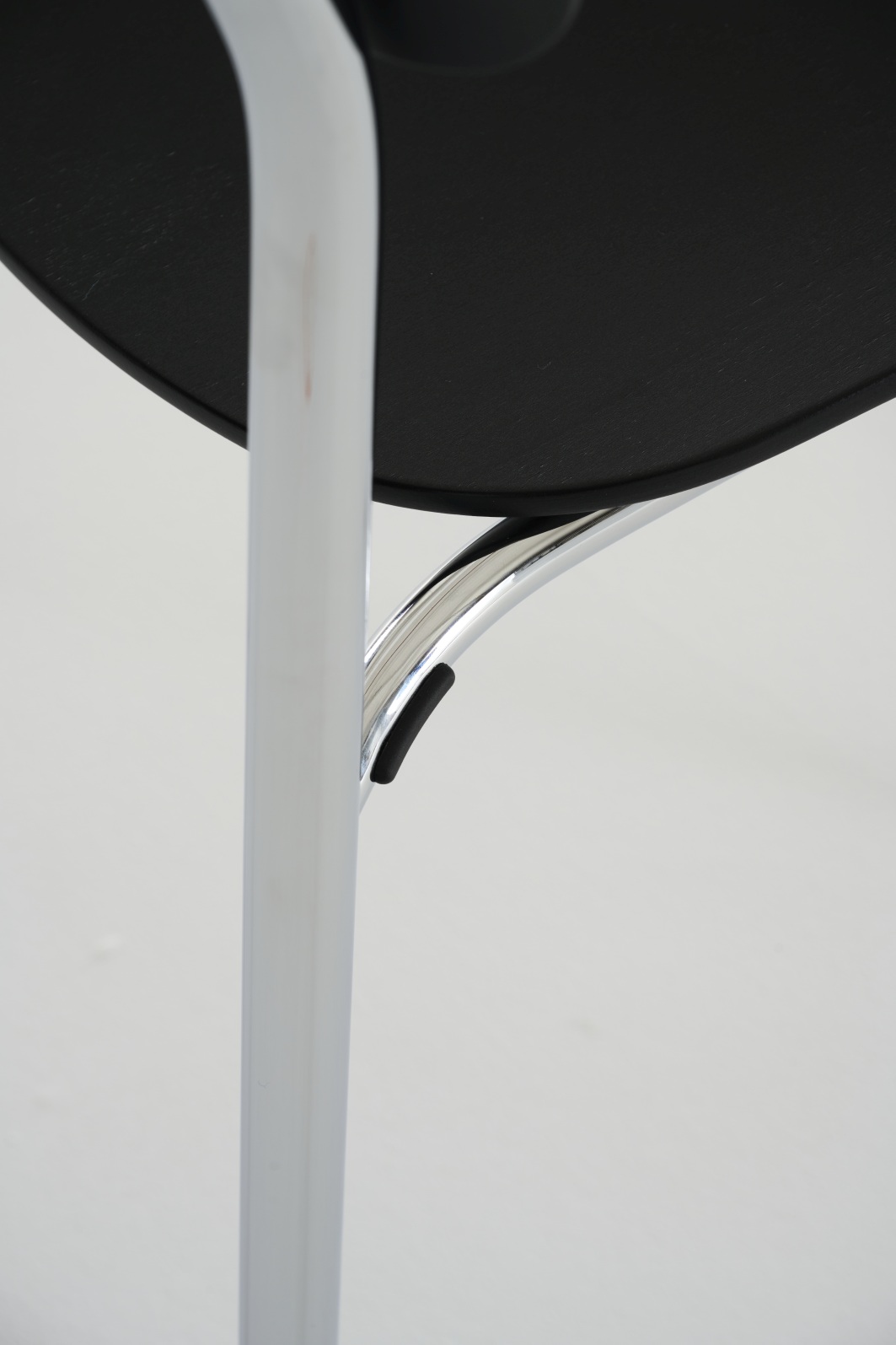 Detailaufnahme des Thonet S 243 Stahlrohrstuhls mit schwarzer Sitzfläche und verchromtem Gestell, ein Designklassiker.