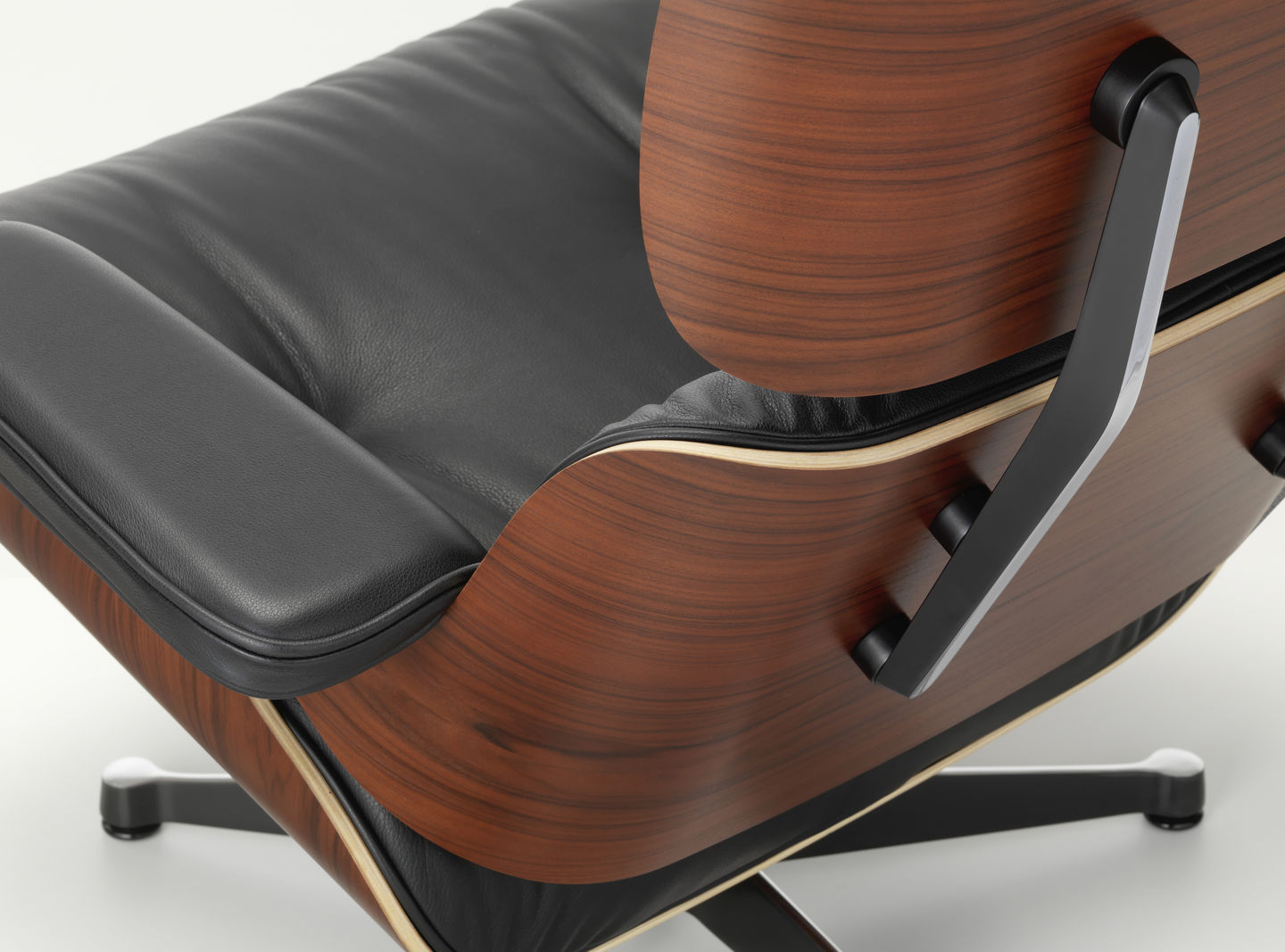 Detailaufnahme des Eames Lounge Chair Sessels von Vitra mit schwarzem Leder und Holzschale.