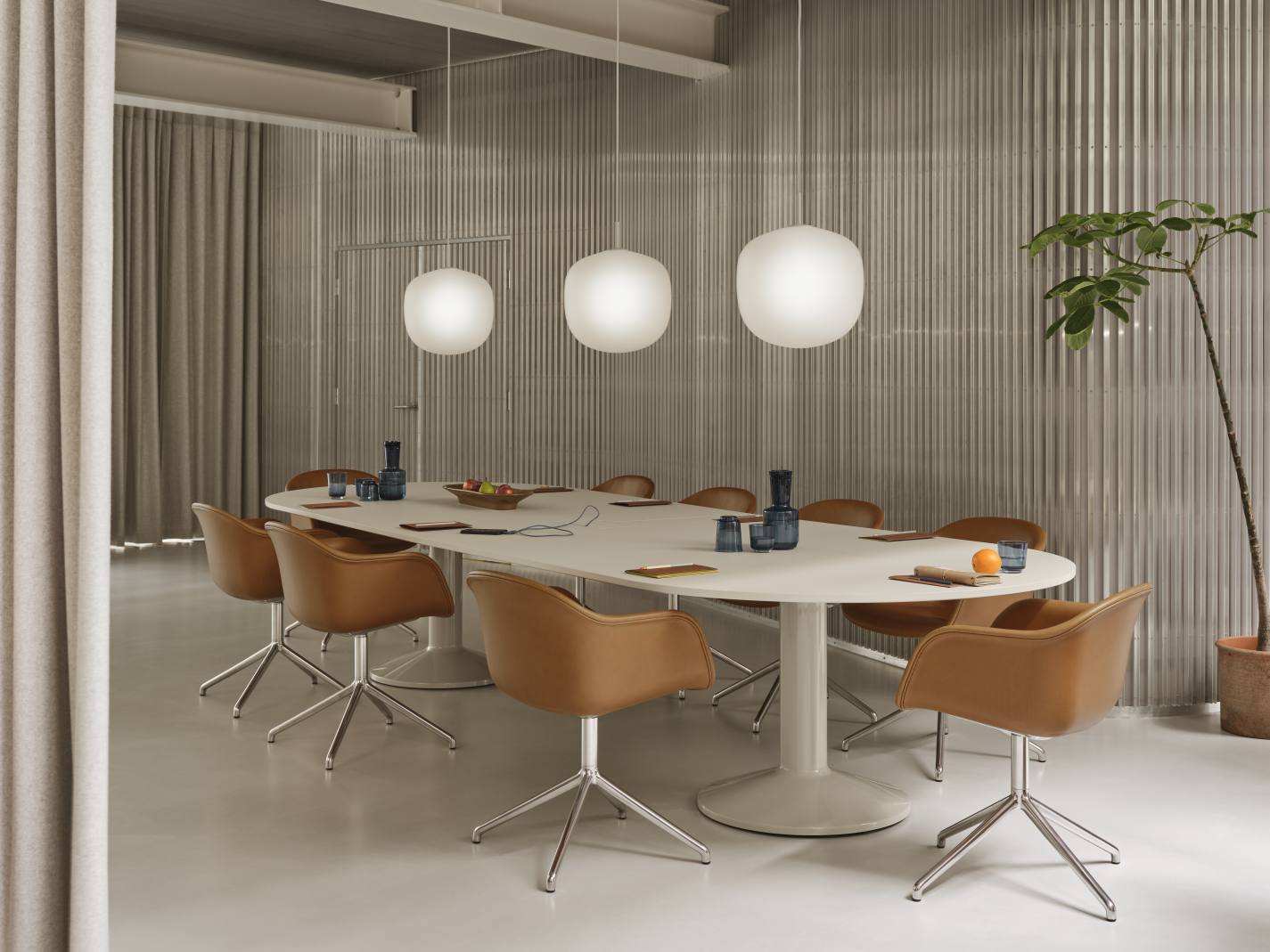 Ovaler Midst Konferenztisch von Muuto in Weiß mit braunen Stühlen und Pendelleuchten in einem Konferenzraum.