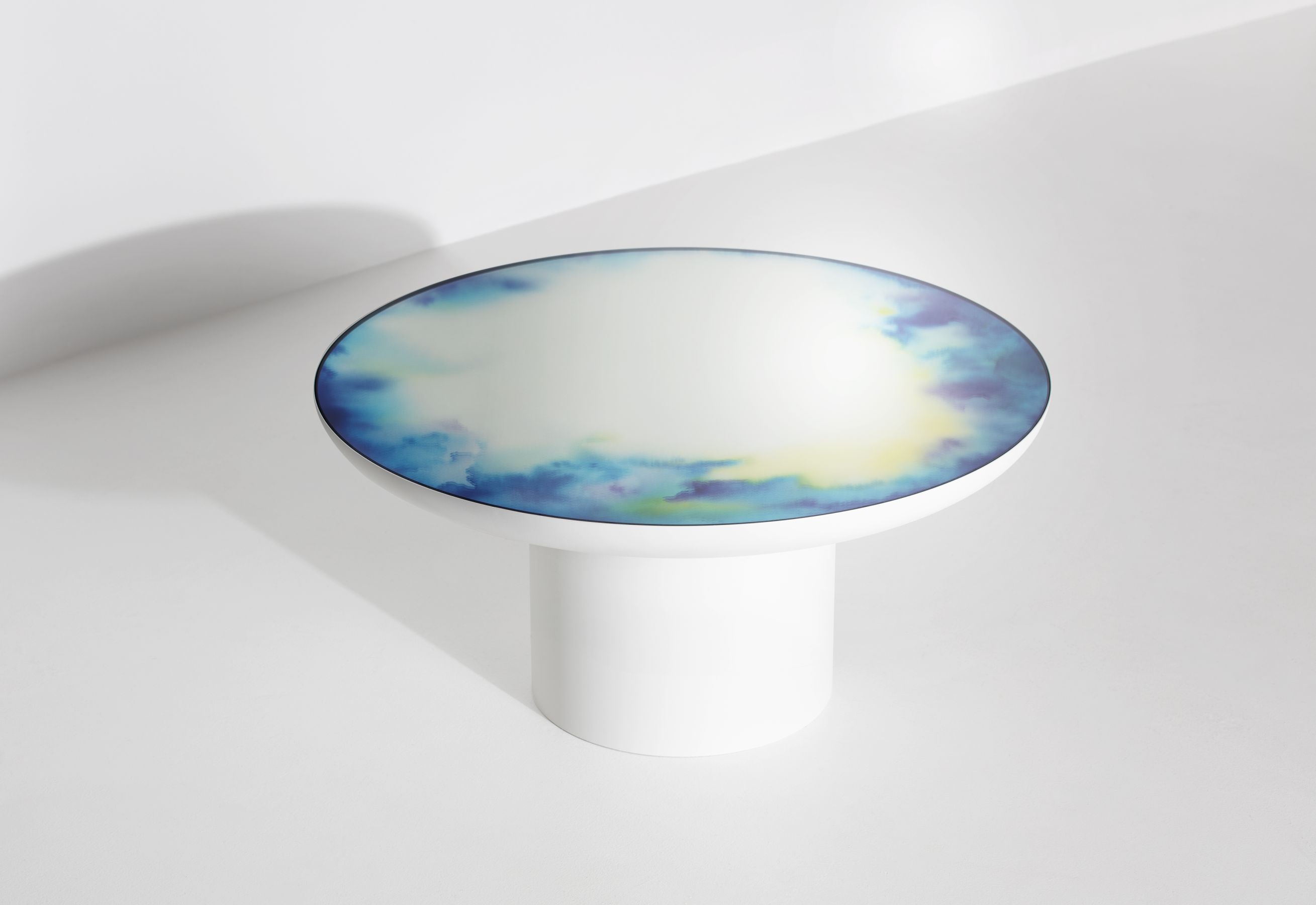 Weißer Francis Couchtisch von Petite Friture mit runder Tischplatte und blau-gelbem Wolkenmuster.