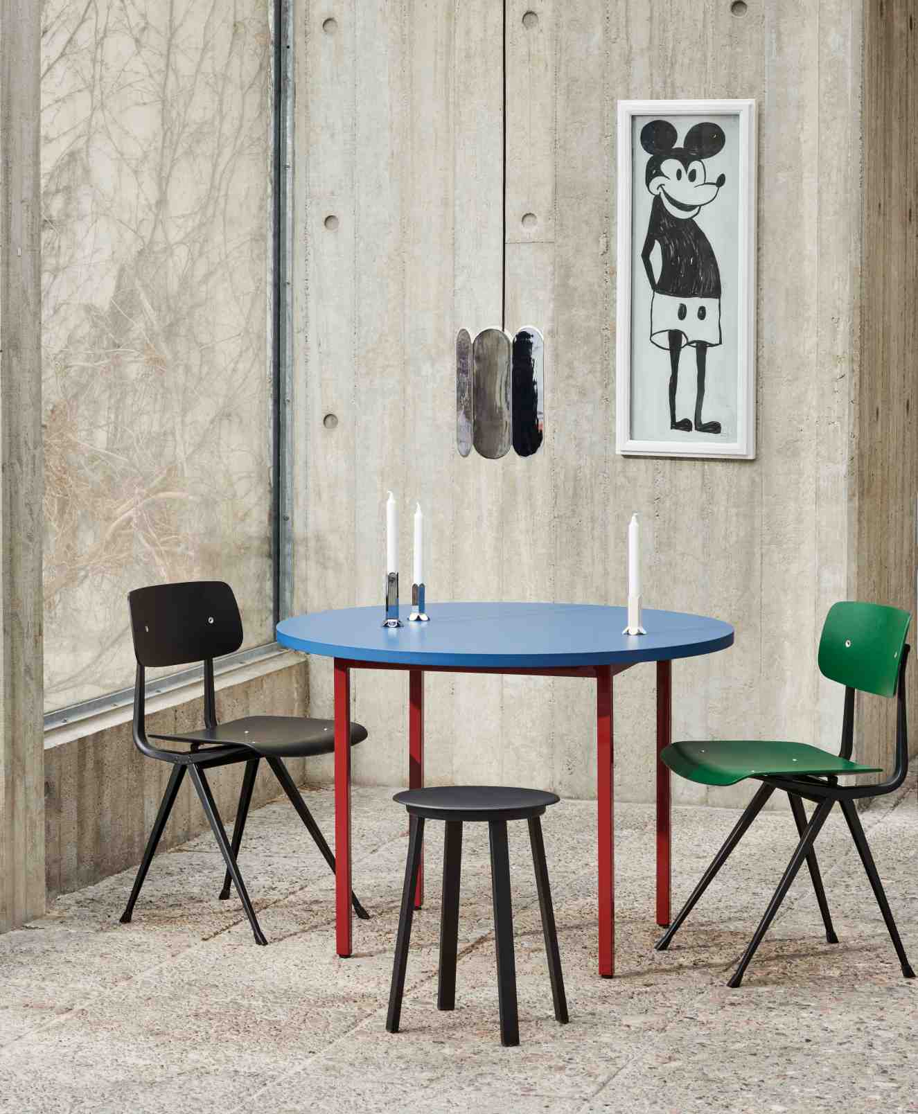 Blauer Two Colour Table Tisch von Hay mit roten Beinen, umgeben von Stühlen und einem Hocker.