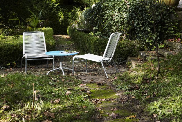 Altorfer Lounge Stuhl Outdoor Embru: Gartenmöbel, zwei Stühle und ein blauer Tisch im Grünen.