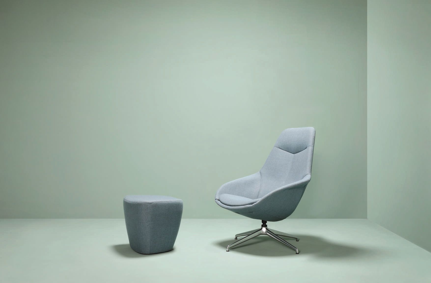 Yonda Sessel von Wilkhahn, ein moderner Loungesessel mit Fußhocker in hellblauem Stoffbezug.