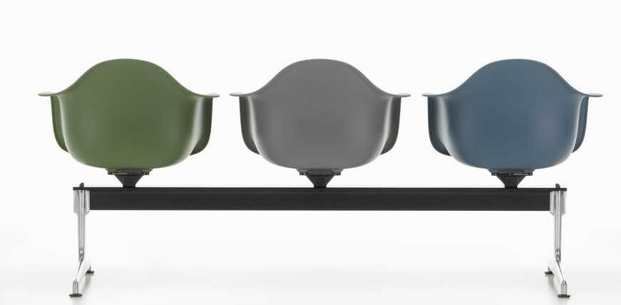 Vitra Eames Plastic Armchair RE auf Traverse, drei farbige Sitzschalen auf schwarzem Gestell.