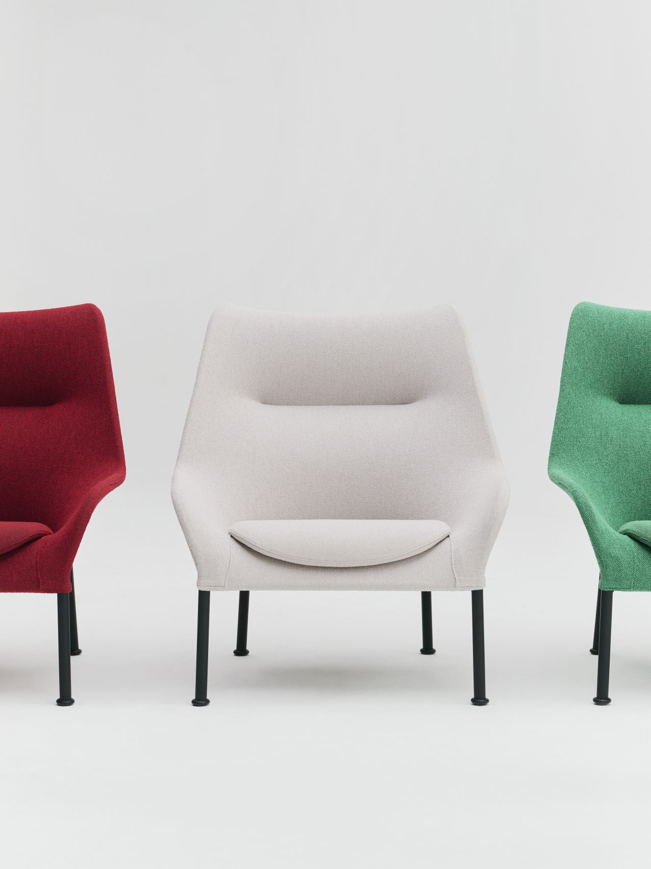 Drei Hay 02 Lounge Chairs Sessel in Rot, Beige und Grün vor einem weißen Hintergrund.