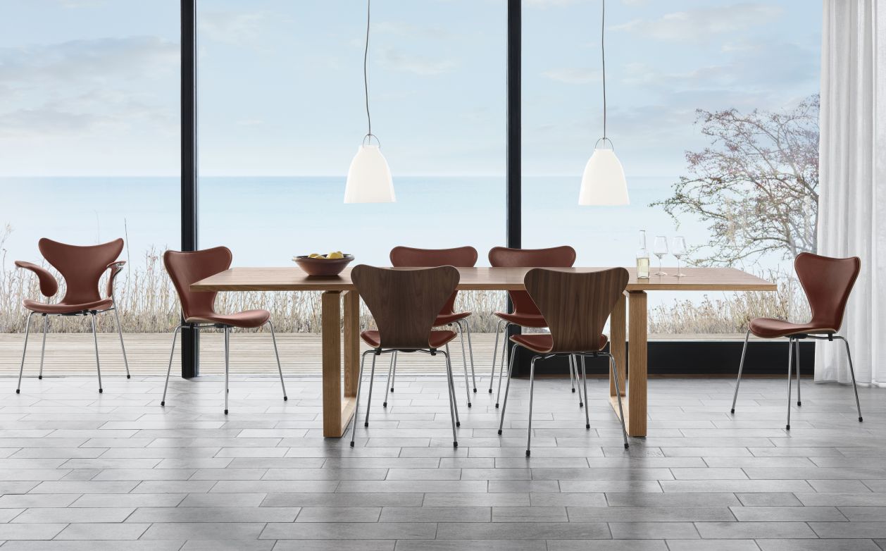 Esszimmer mit Siebener Stühlen, Fritz Hansen Jubiläumsmodell in Leder Grace Kastanie. Designklassiker.