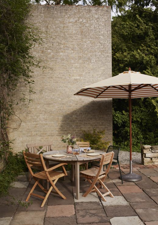Selandia Armchair Sessel von Skagerak by Fritz Hansen, Gartensitzgruppe mit Sonnenschirm im Außenbereich.