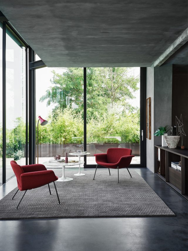 Zwei rote KN04 Stühle von Knoll International in modernem Wohnzimmer mit Teppich.