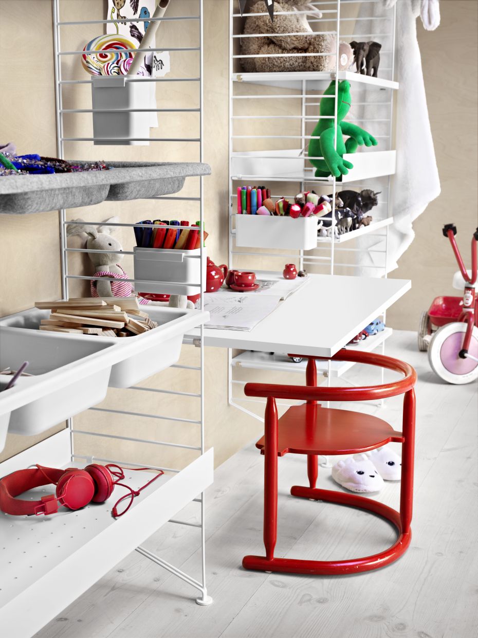 Detailaufnahme des String Furniture Regalsystems mit Work Desk Schreibtischplatte und Kindermöbeln.