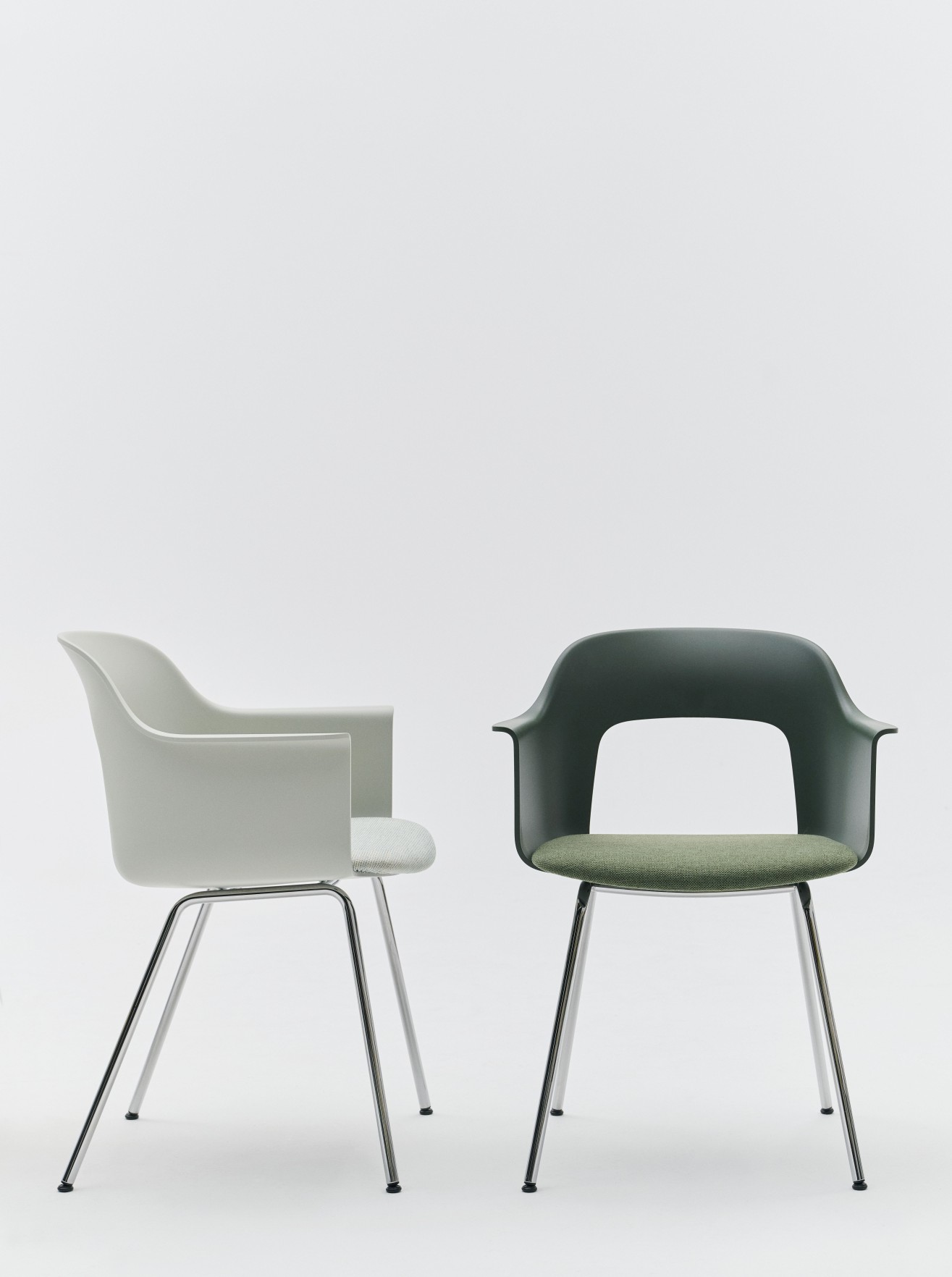 Zwei Hay Layout Armchair 213 Armlehnstühle in Grau und Grün mit Chromgestell vor weißem Hintergrund.