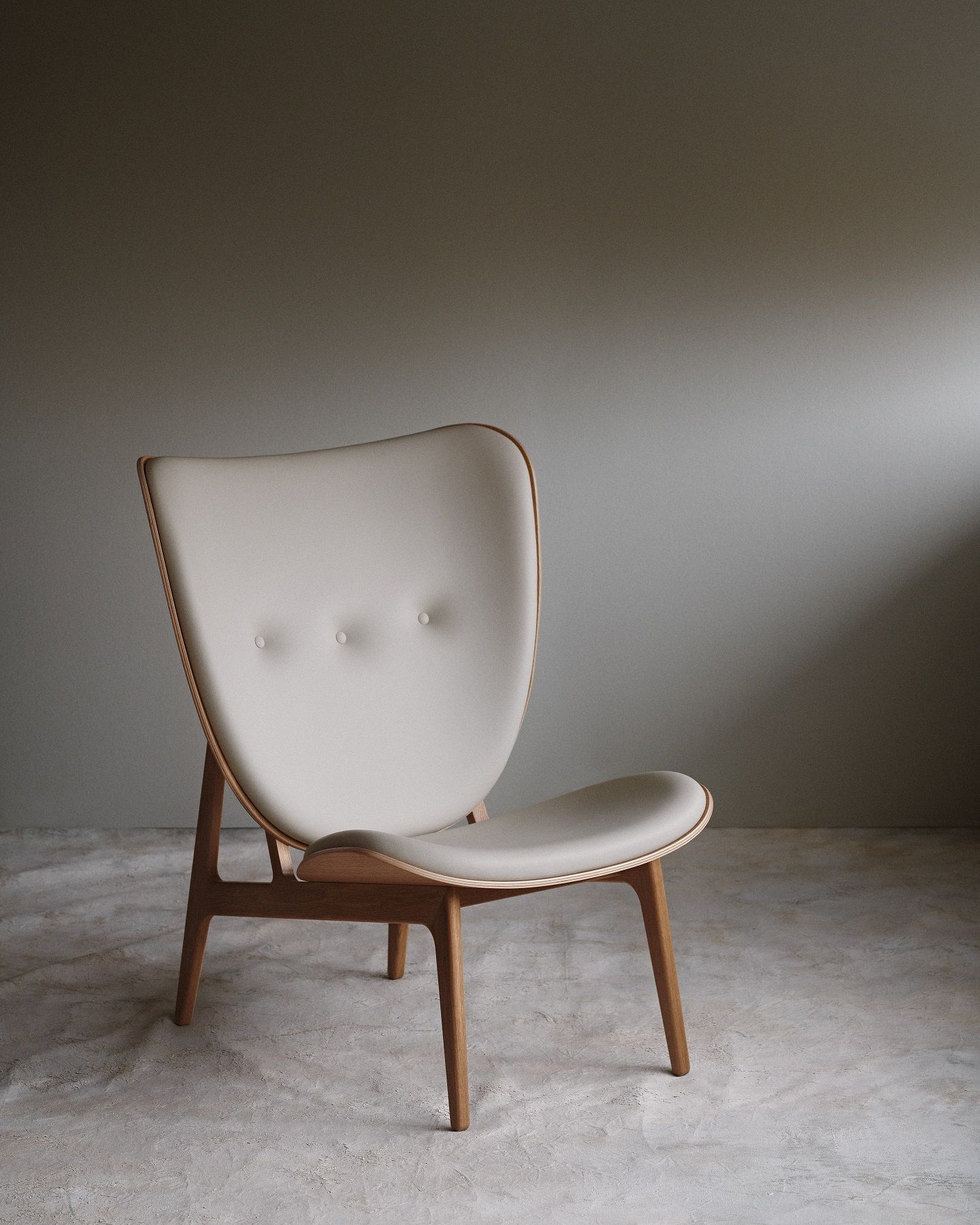 NORR11 Elephant Lounge Chair Sessel mit hellem Polster und Holzgestell vor grauer Wand.