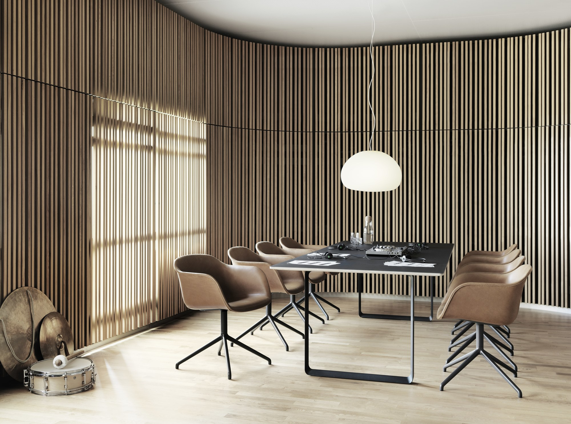 Helle Muuto Fluid Pendelleuchte Small über einem Konferenztisch mit Stühlen in einem modernem Büro.