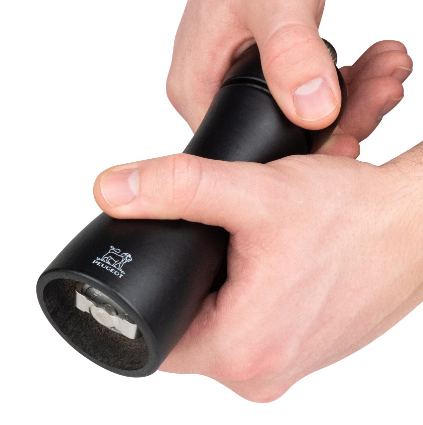 Nahaufnahme: Hände bedienen schwarze Peugeot Tahiti Mühle, ideal für Salz und Pfeffer.