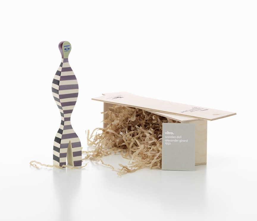 Vitra Wooden Doll No. 16, handbemalte Holzfigur mit Streifenmuster, neben offener Holzbox mit Füllmaterial.