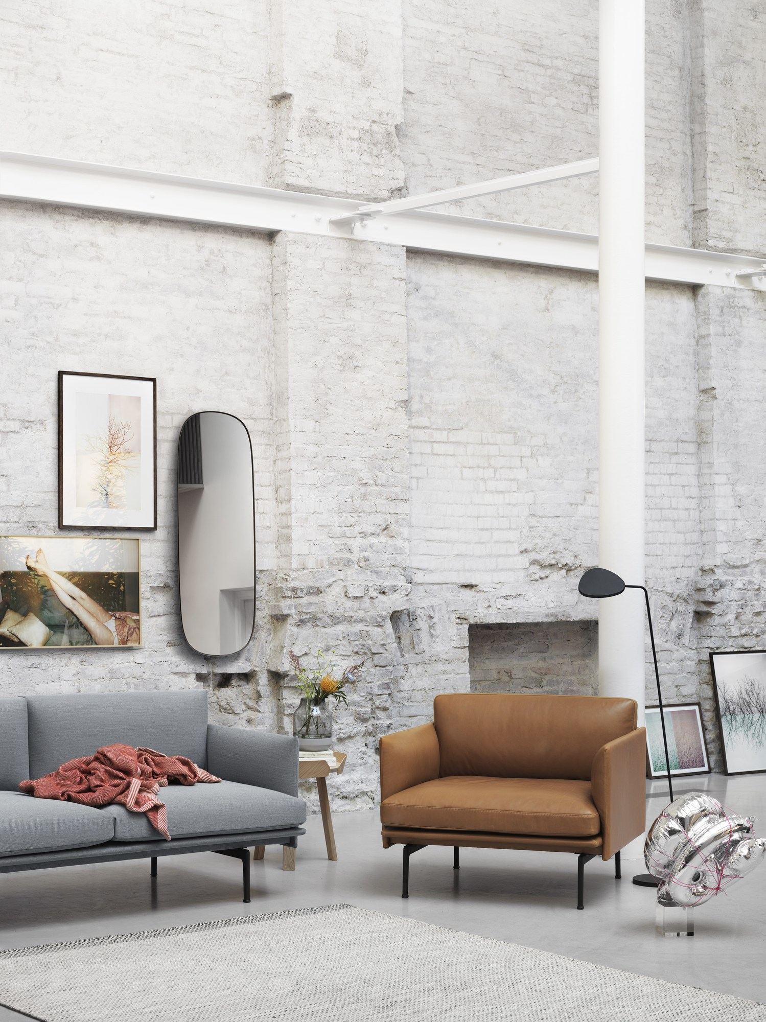Muuto Leaf Floor Lamp Stehleuchte in Schwarz neben einem braunen Ledersessel in modernem Wohnzimmer.