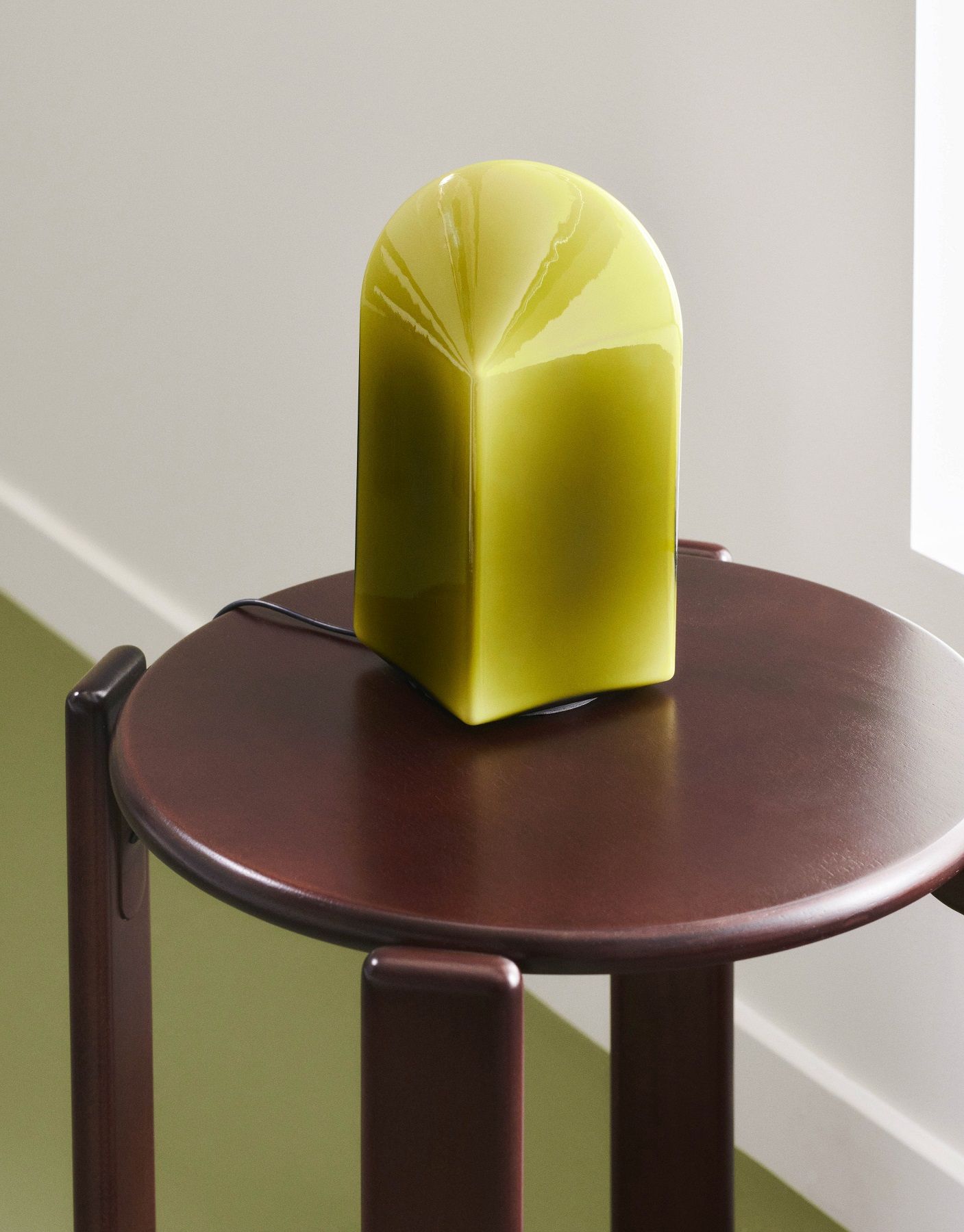 Nahaufnahme des Hay Rey Stool Hockers mit einer modernen, gelbgrünen Lampe auf der runden Tischplatte.