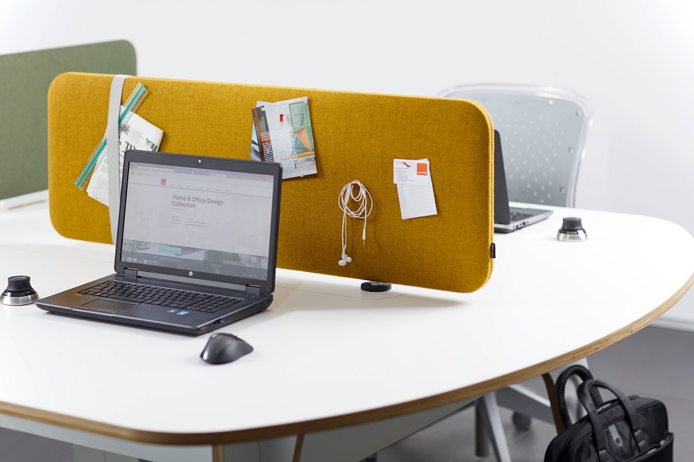 Gelbes Cascando Pillow Desk Akustikelement am Schreibtisch mit Laptop und Notizen. Schallschutz für Büro.