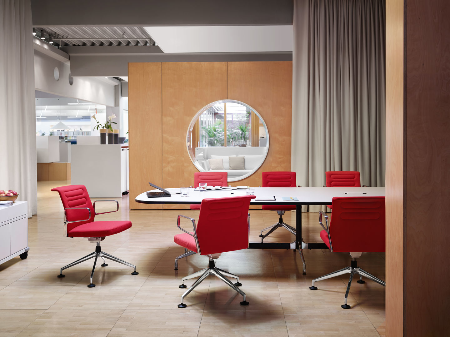 AC5 Studio Bürodrehstuhl von Vitra in Rot um einen Konferenztisch in einem modernen Büro.