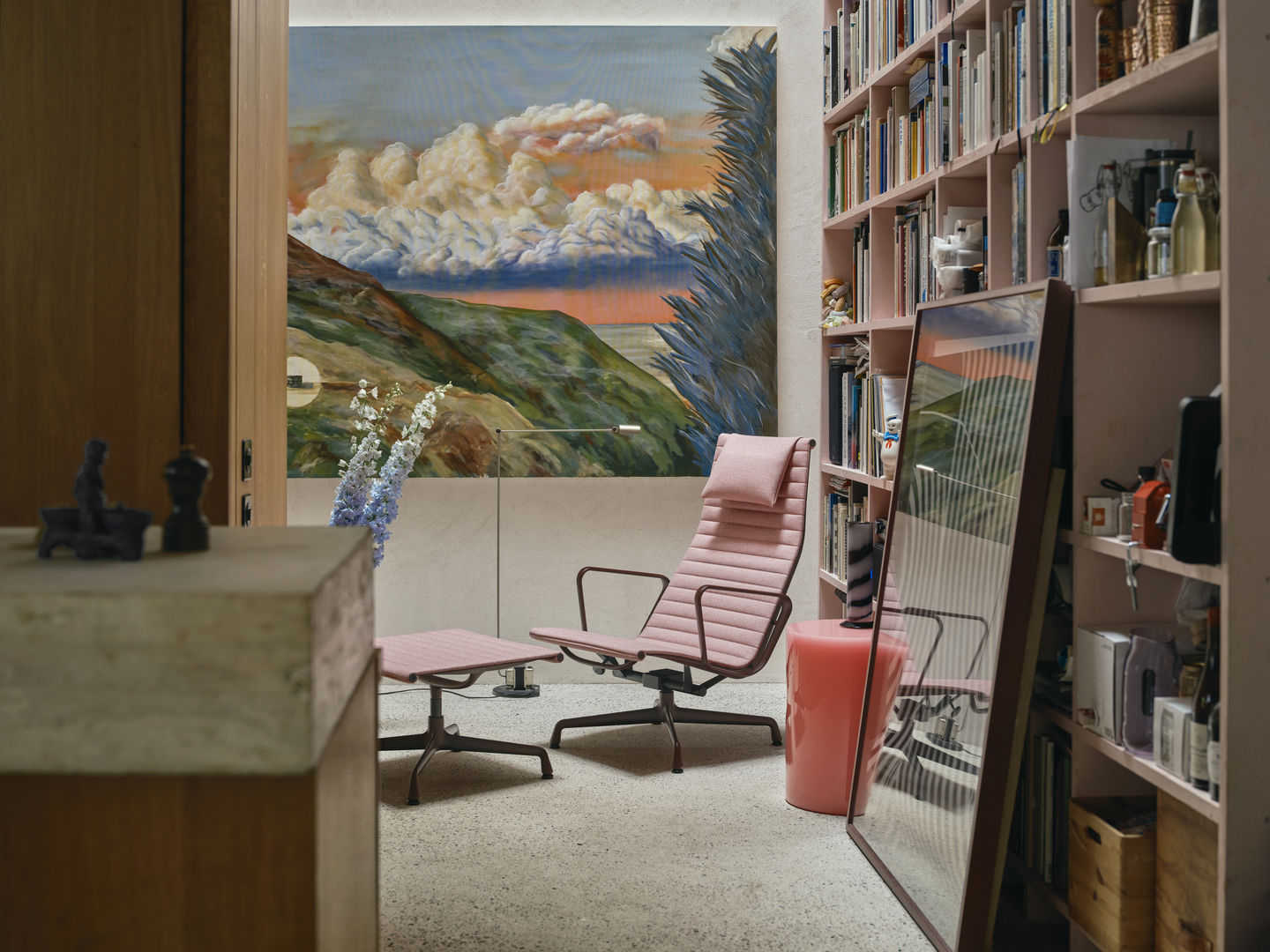 Rosa Vitra Aluminium Chair EA 125 mit Hocker in stilvollem Interieur, Designklassiker für Wohnzimmer und Büro.