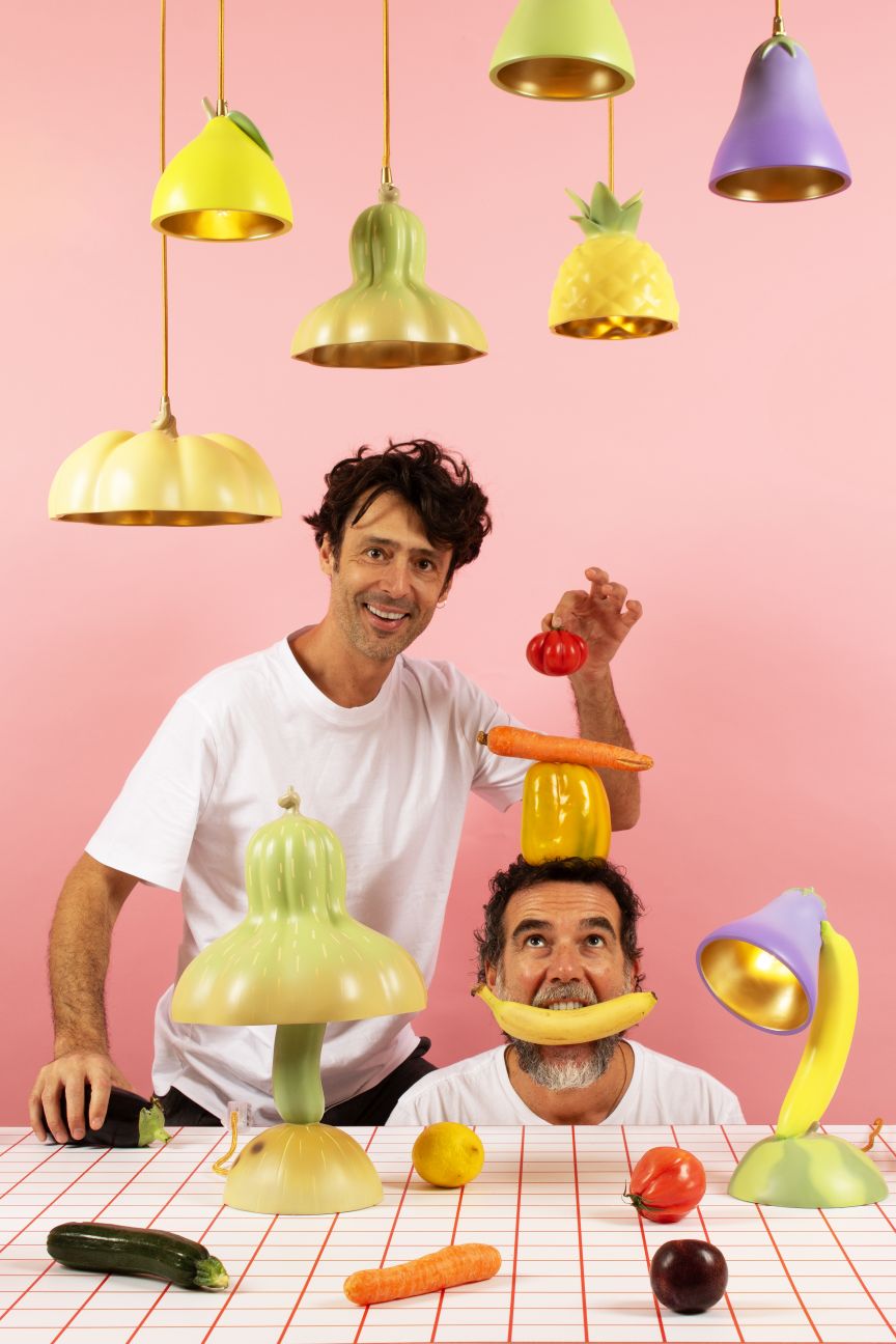 Verspieltes Produktfoto der Seletti Vitamin Table Lamp Tischleuchte Aubergine mit Gemüse und zwei Männern.